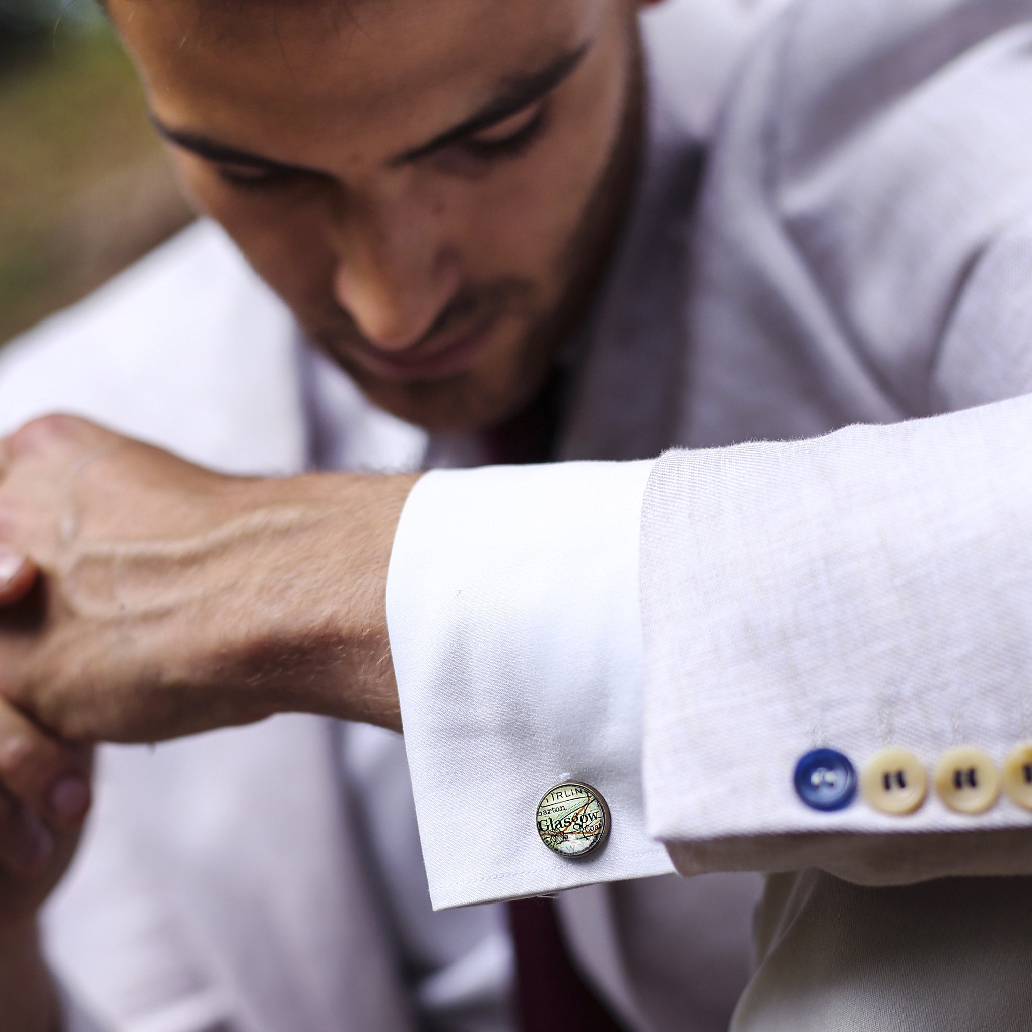 Man in suit wearing Personalised map cufflinks in antique bronze color