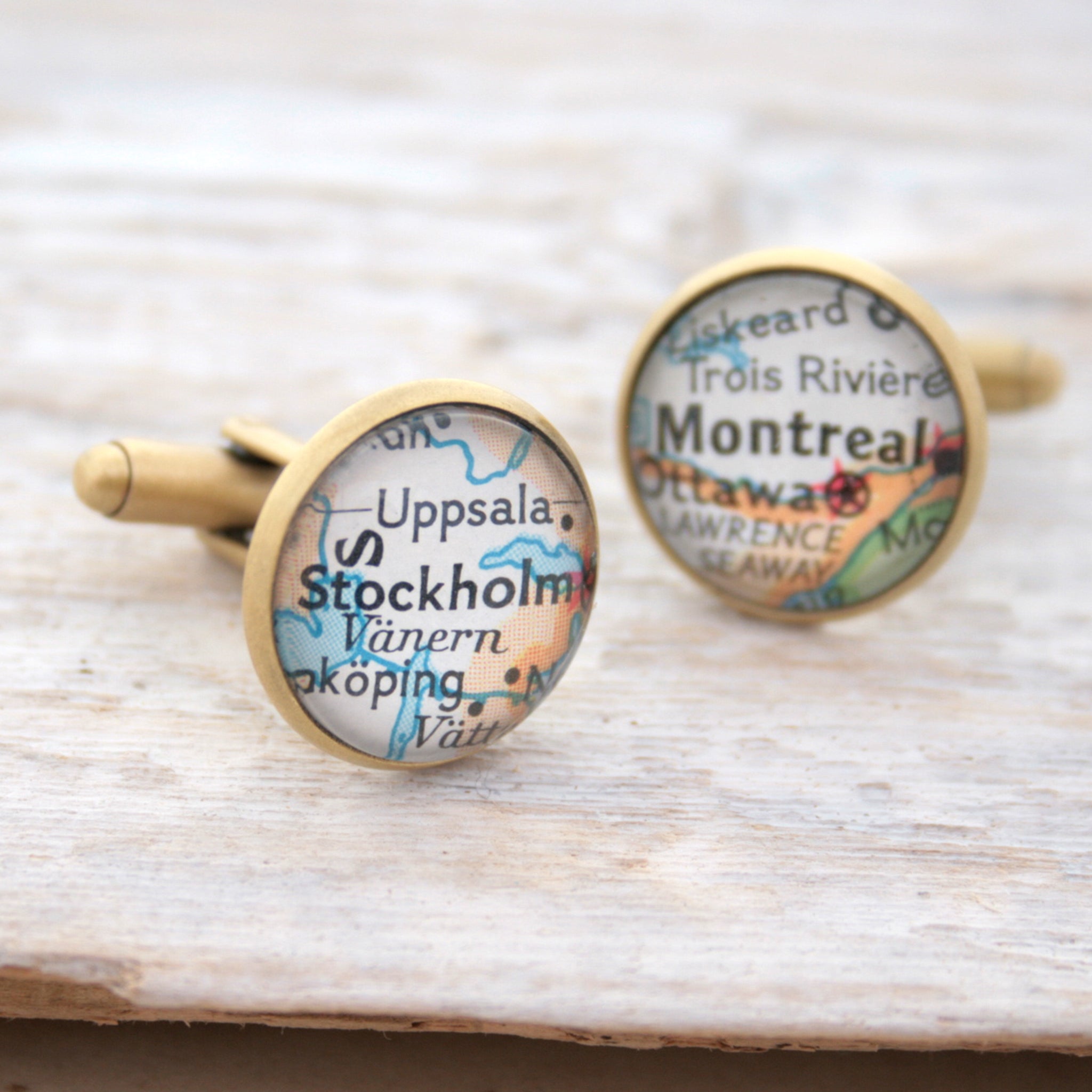 Personalised map cufflinks in brushed bronze color featuring maps of Stockholm and Montreal