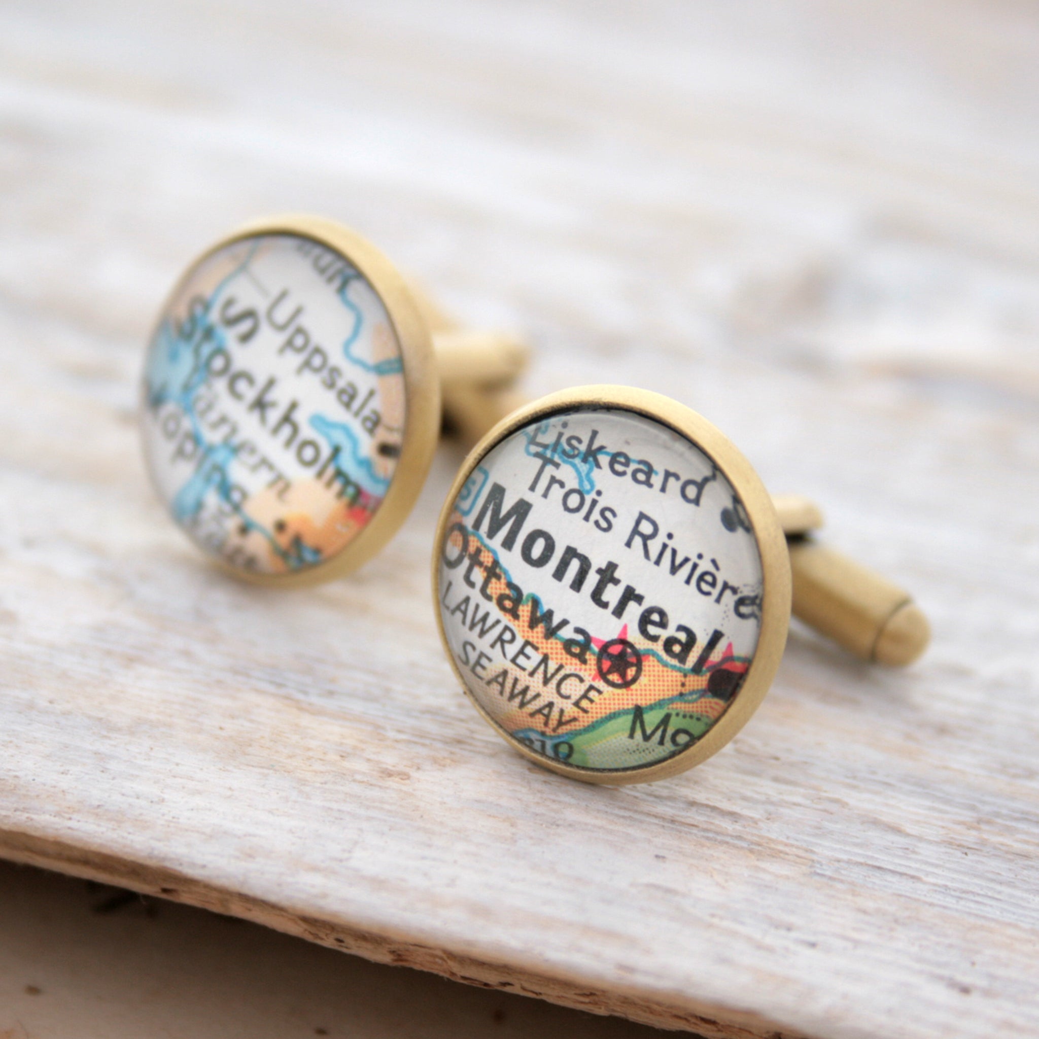 Personalised map cufflinks in brushed bronze color featuring maps of Stockholm and Montreal