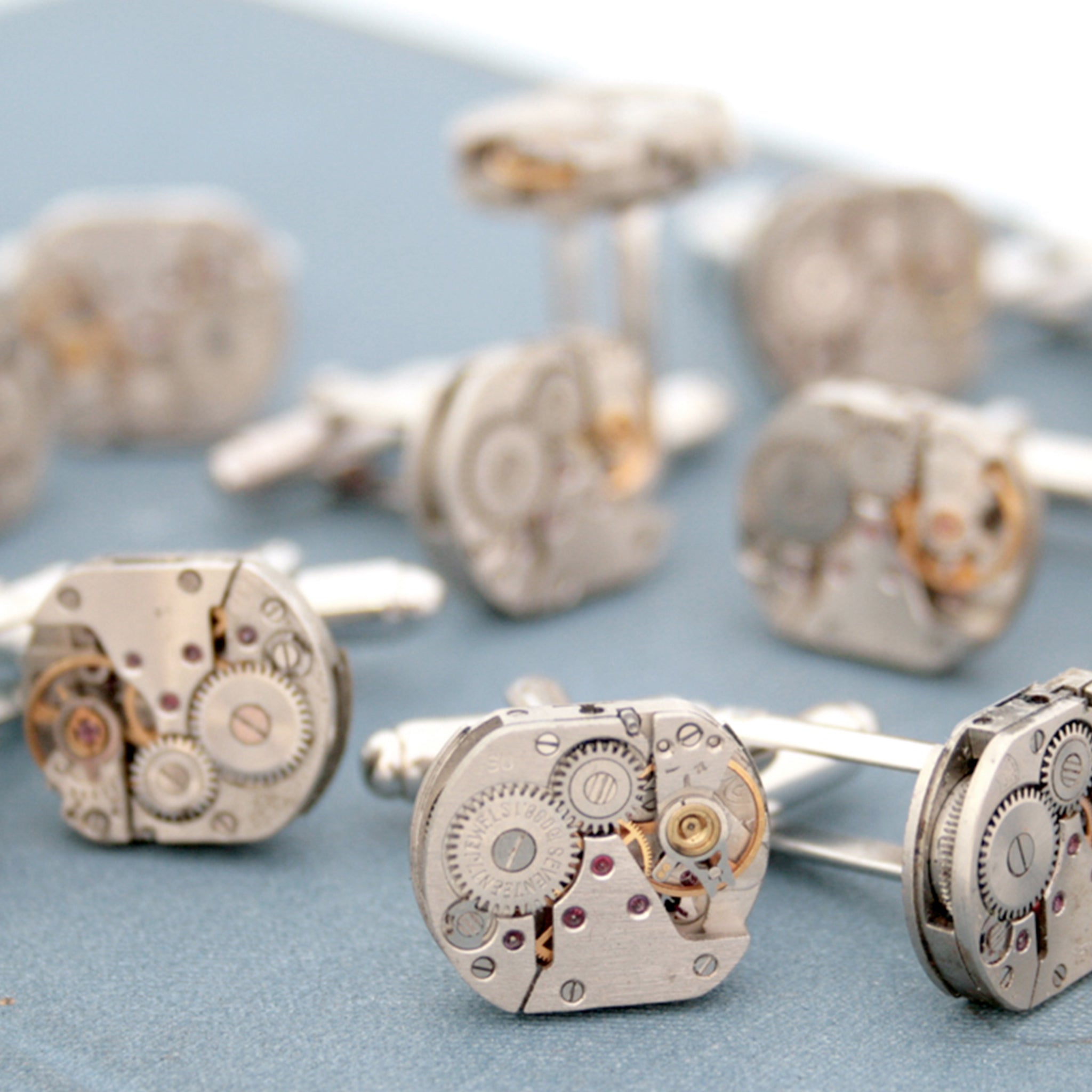 Many sets of steampunk cufflinks for men featuring antique watch movements
