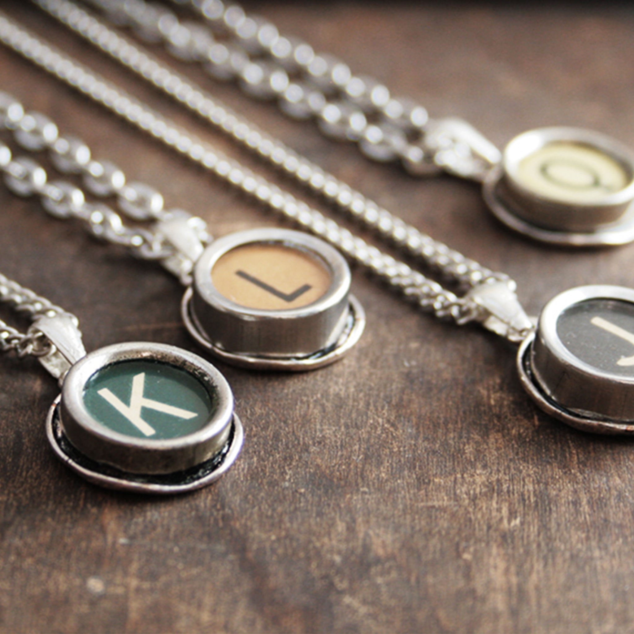 Four typewriter necklaces made of real typewriter keys in green, brown, black and ivory color