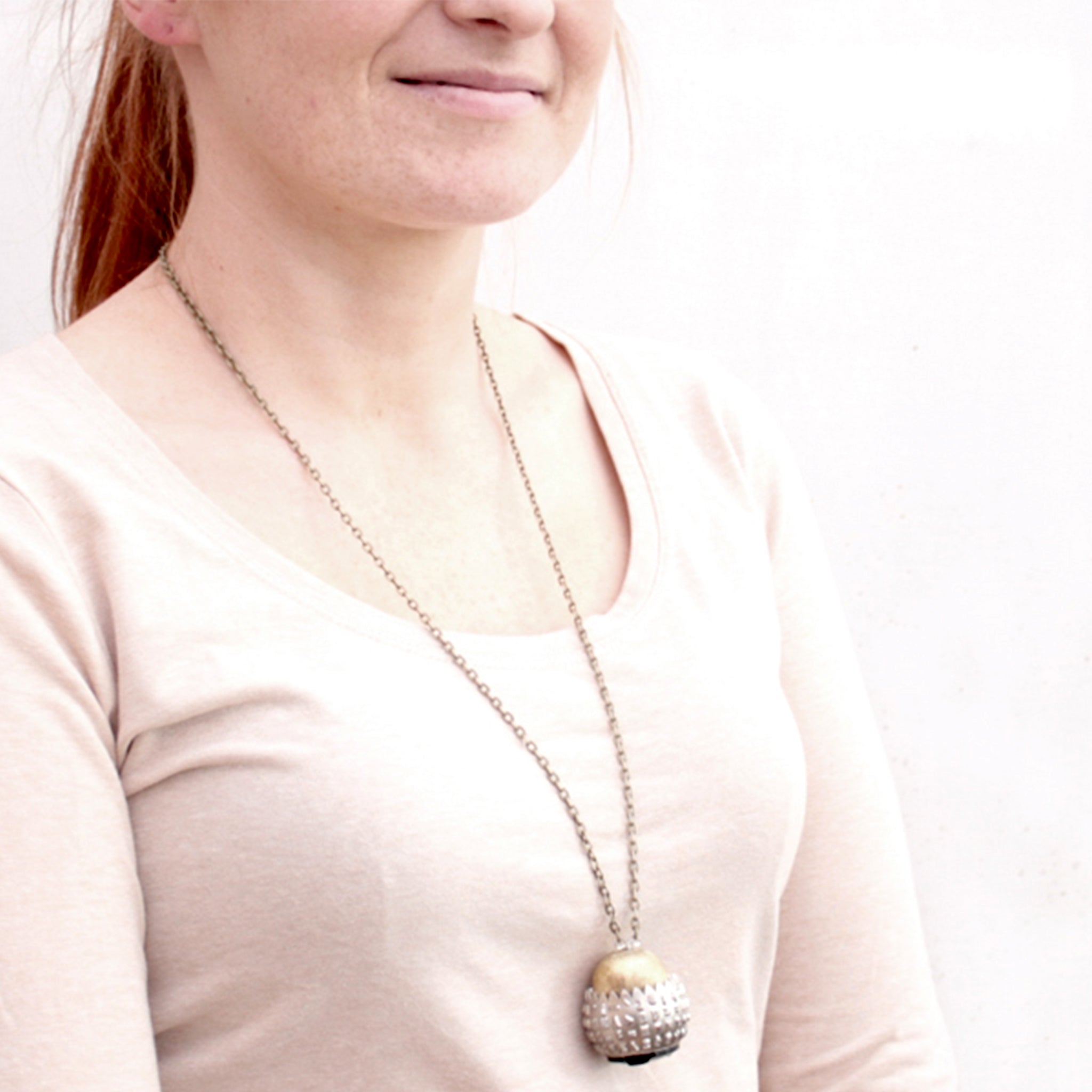 IBM Selectric typewriter font ball with large gold tone bead turned into eye catching necklace worn