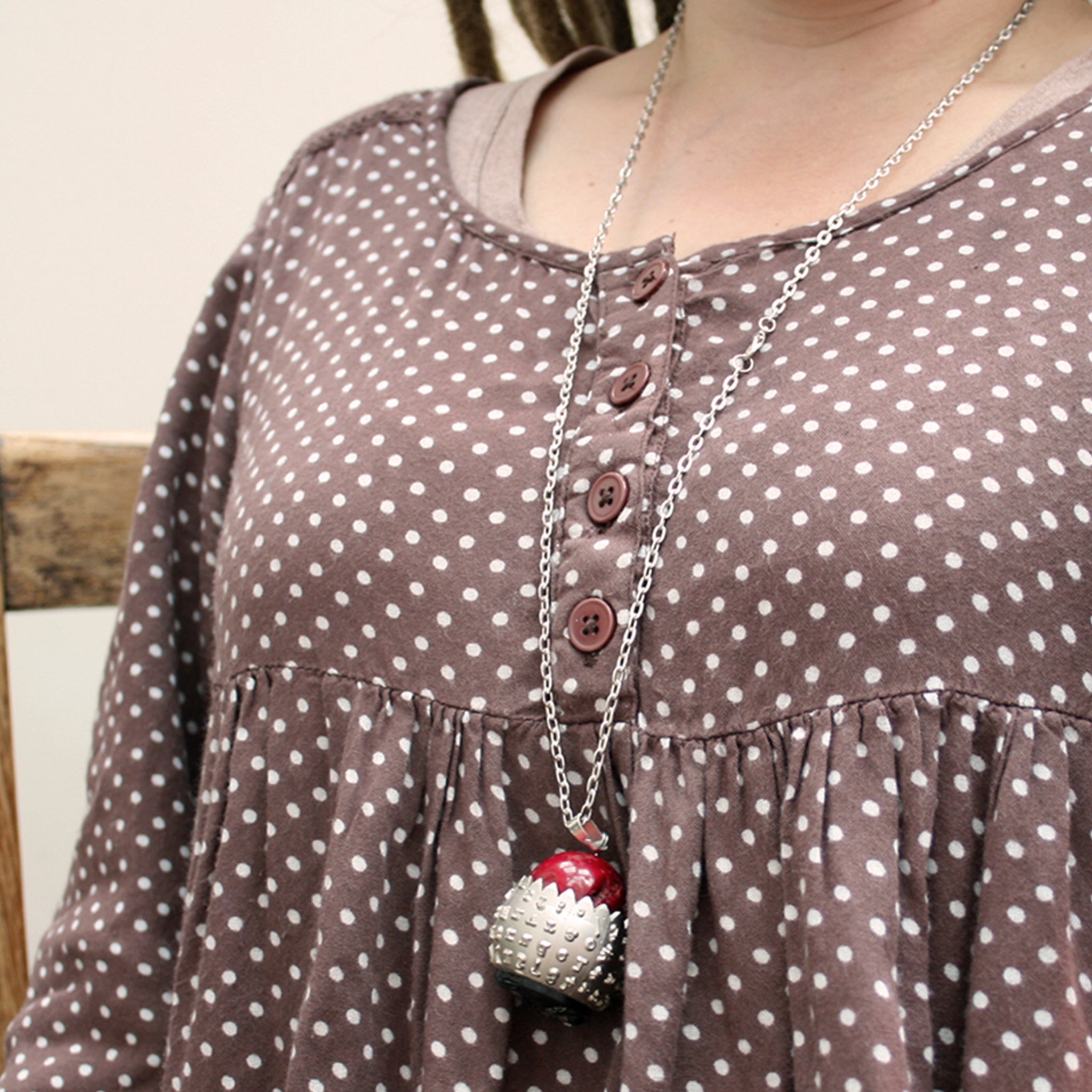IBM Selectric typewriter font ball with large coral bead turned into eye catching necklace worn
