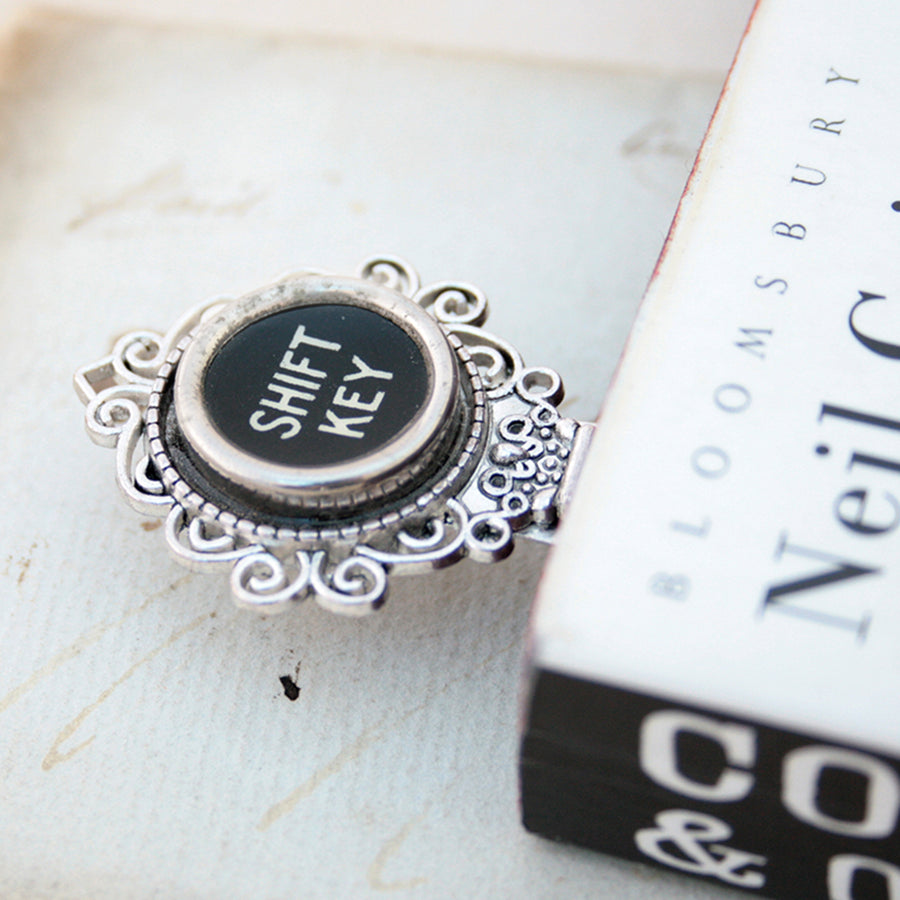 Metal bookmark made of real Shift Key from the typewriter in a book