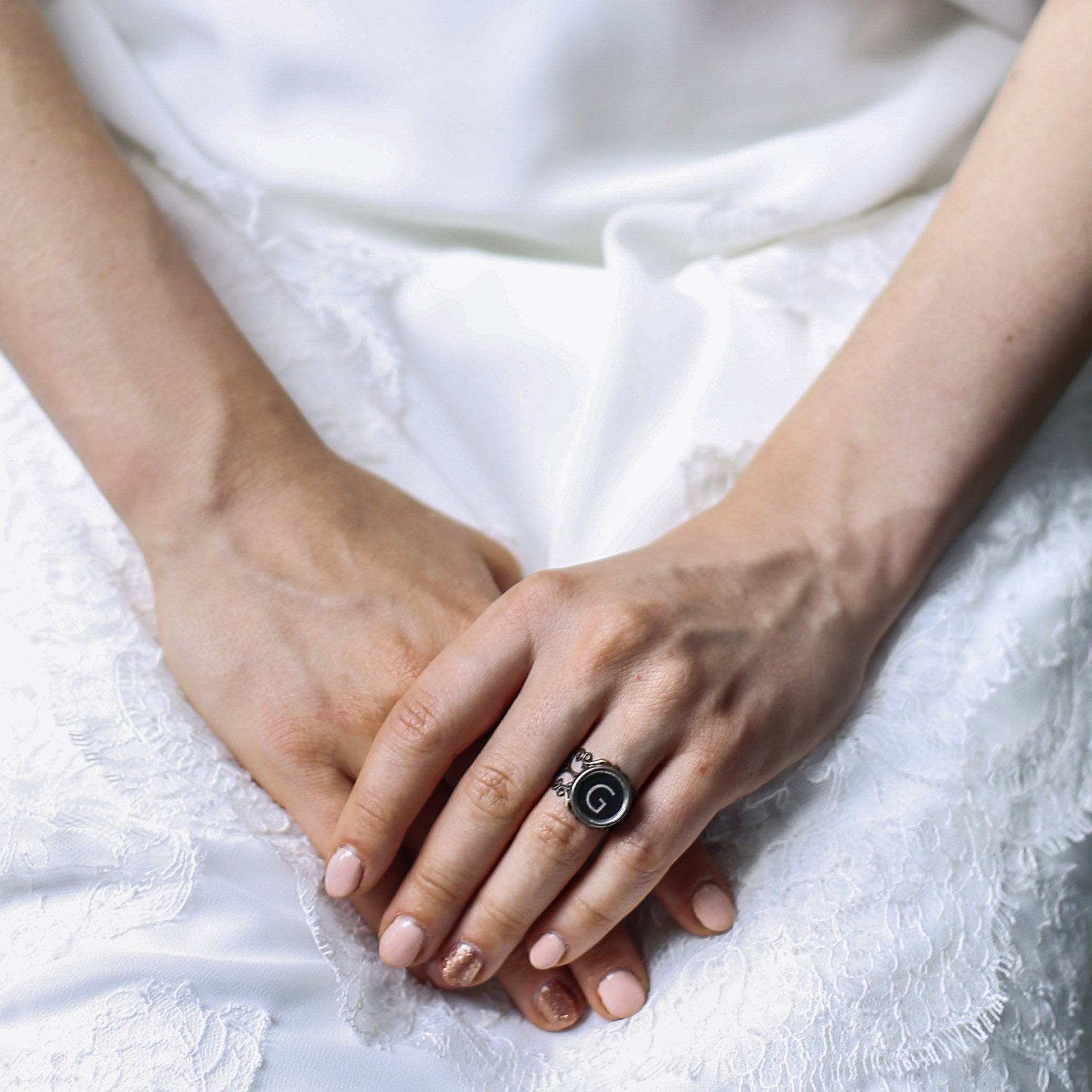 Bride wearing initial ring made of authentic vintage typewriter key in black color