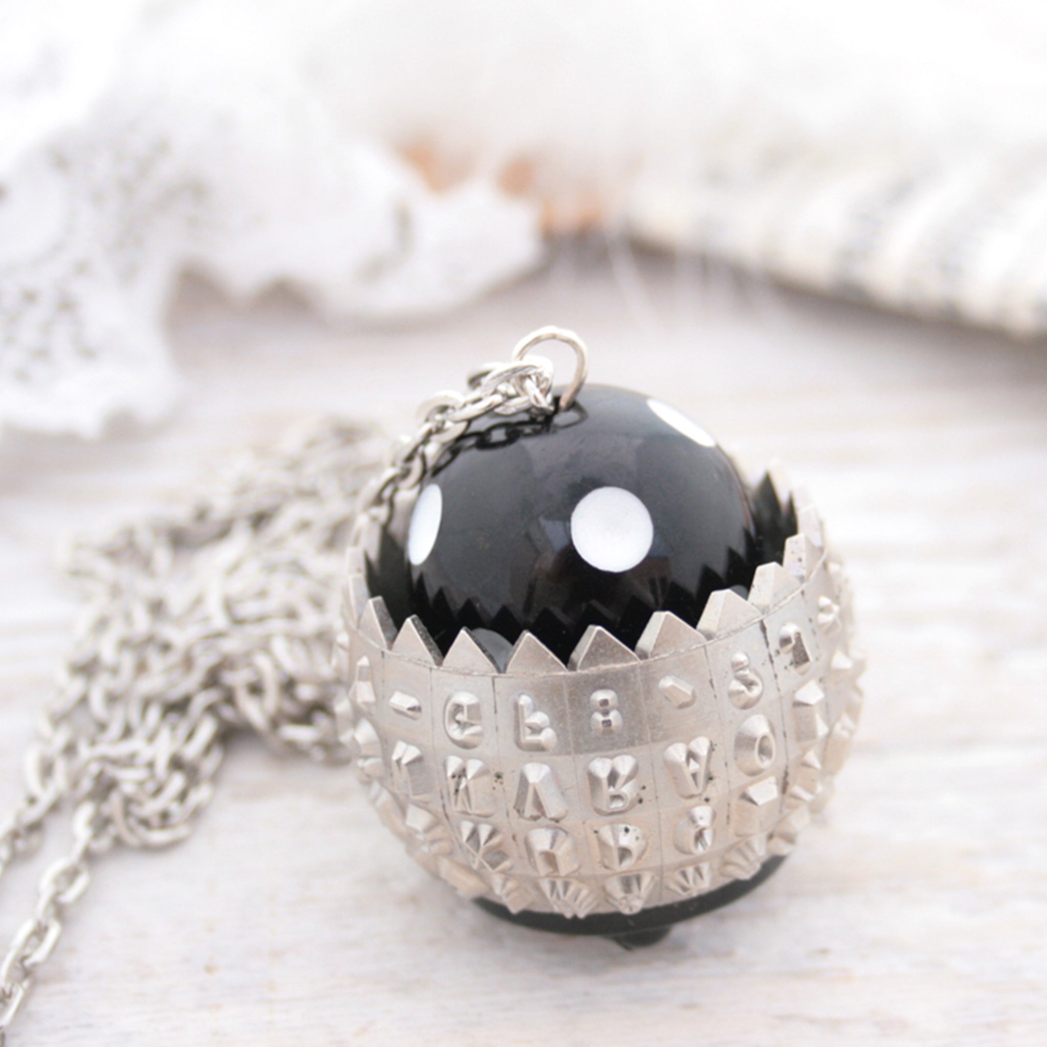 IBM Selectric typewriter font ball with large black and white bead turned into a necklace