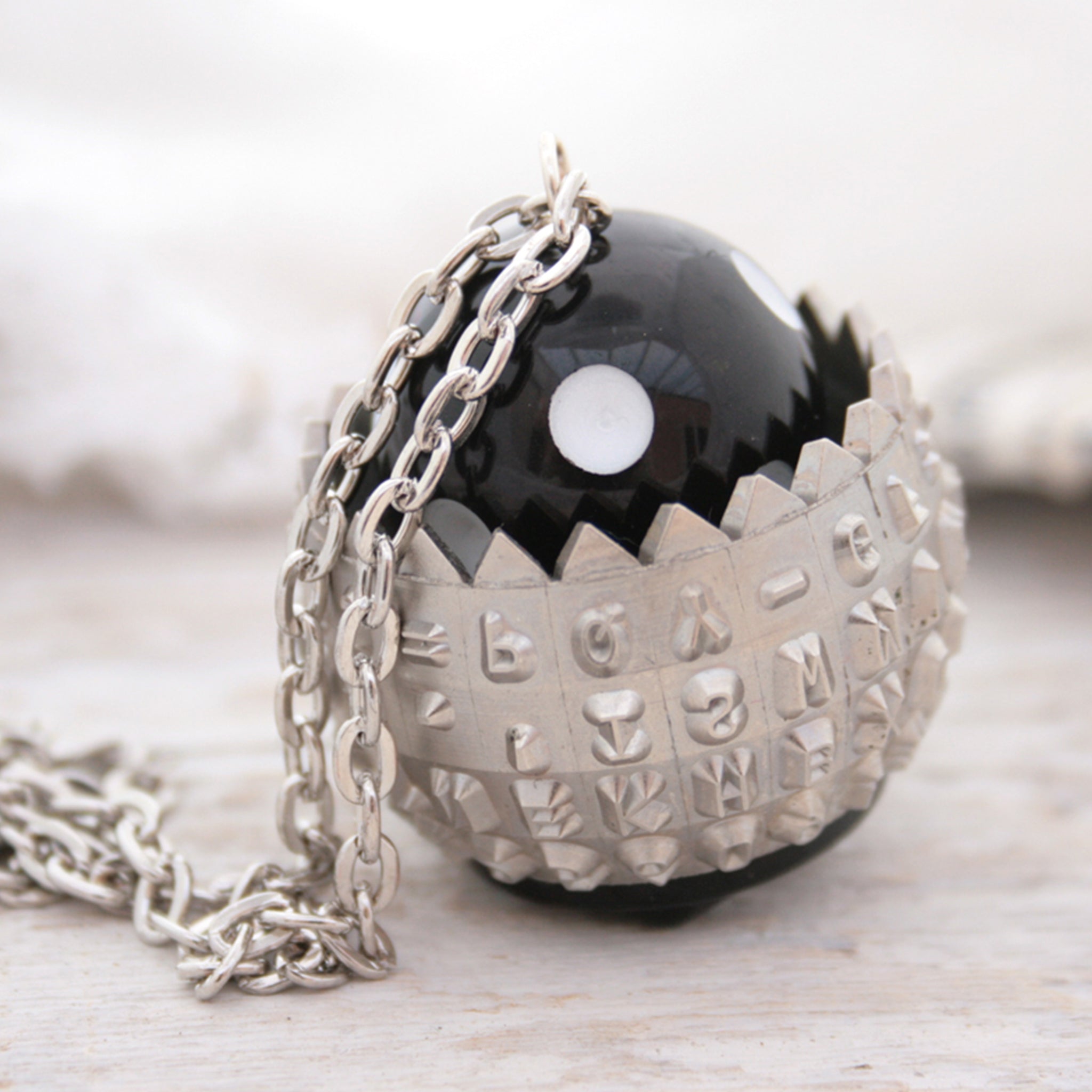 IBM Selectric typewriter font ball with large black and white bead turned into a necklace