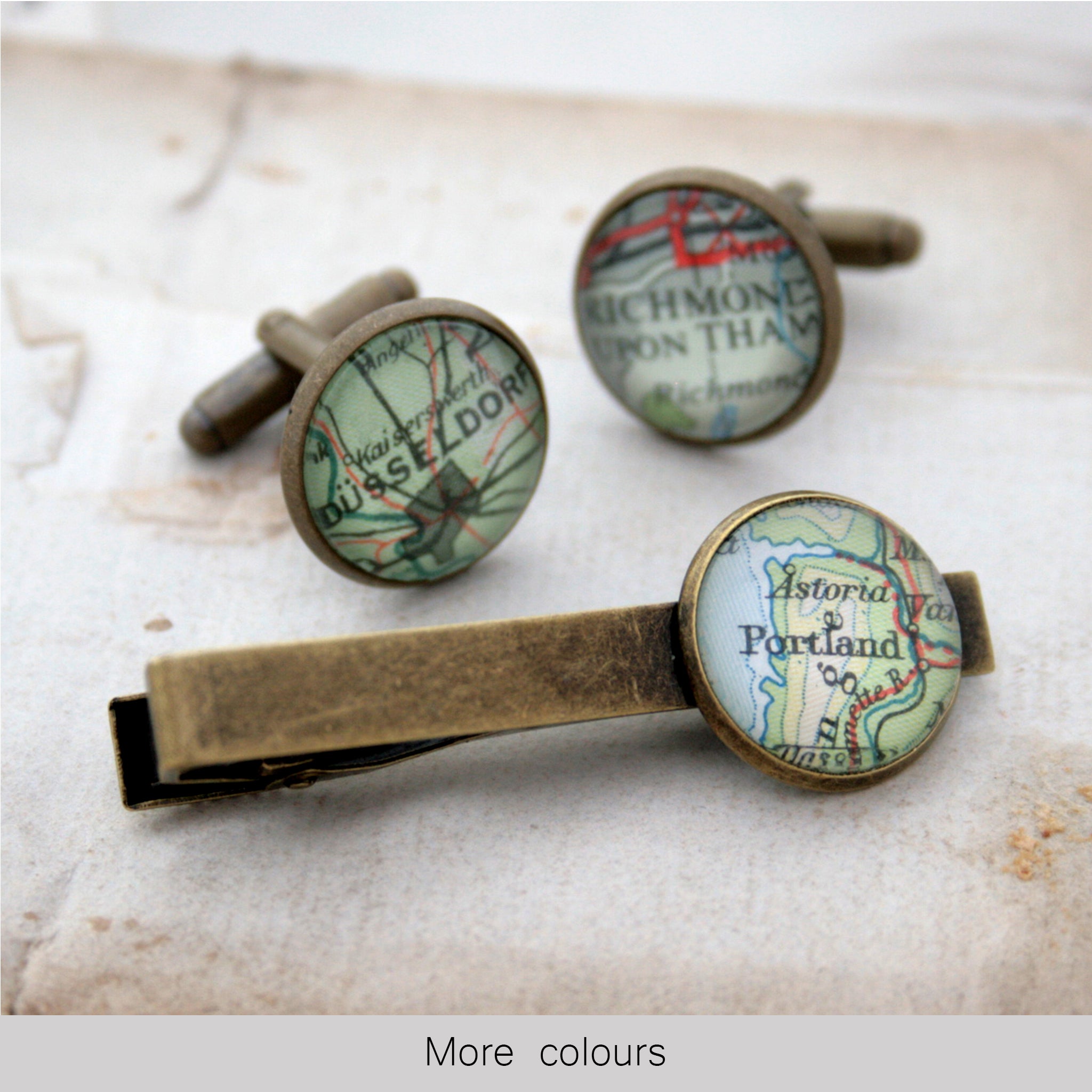 Tie clip and cufflinks in bronze color featuring selection of map locations