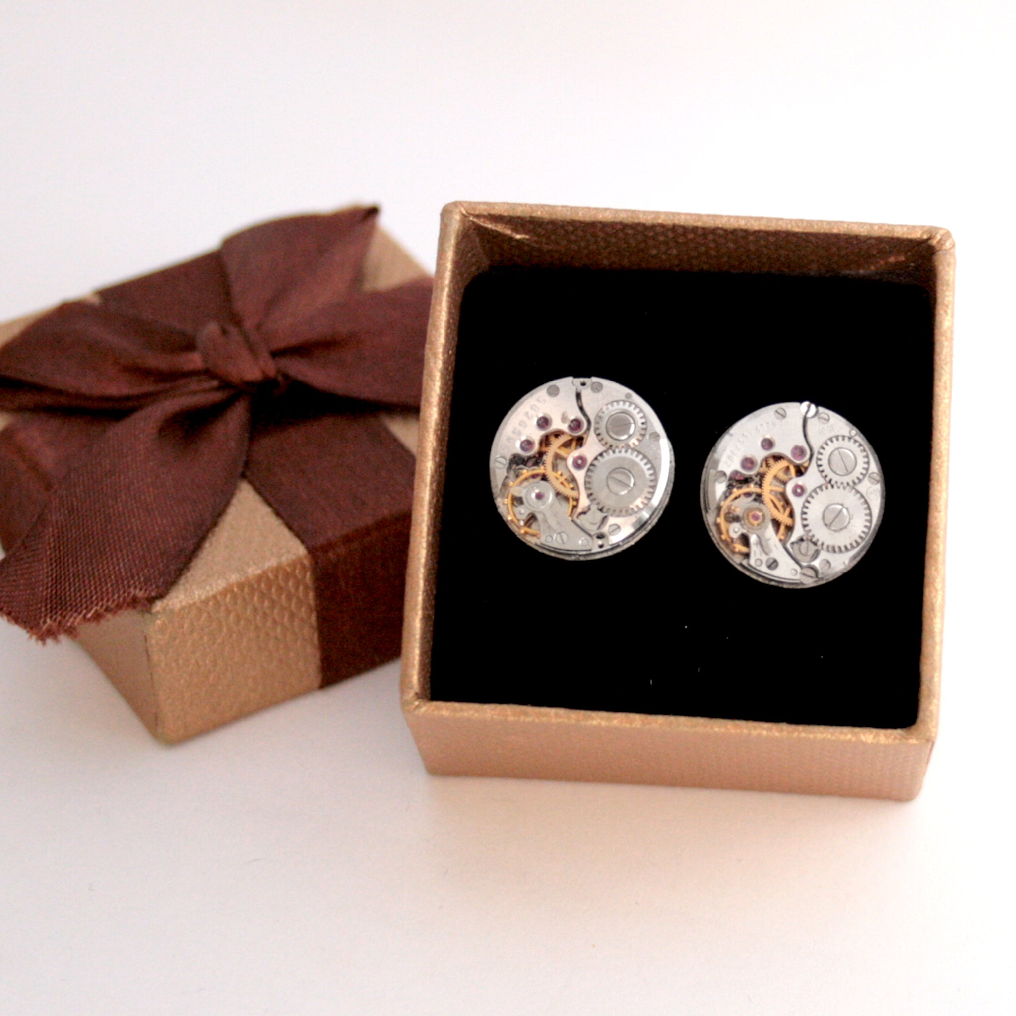 Round watch cufflinks in steampunk style featuring antique watch movements in a brown box