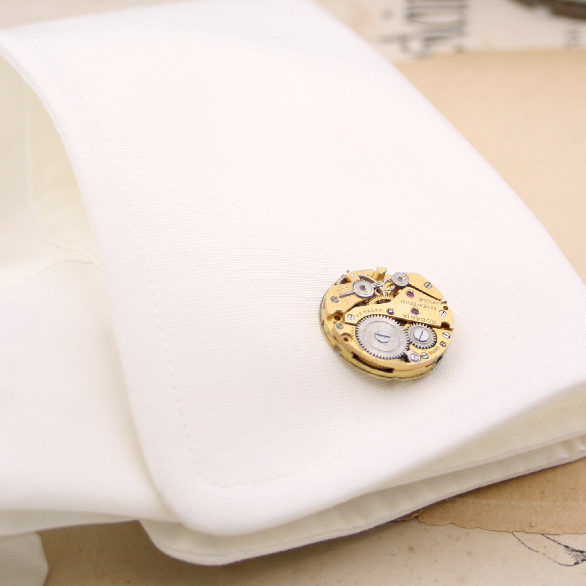 gold steampunk cufflinks featuring antique watch movements in a shift cuff