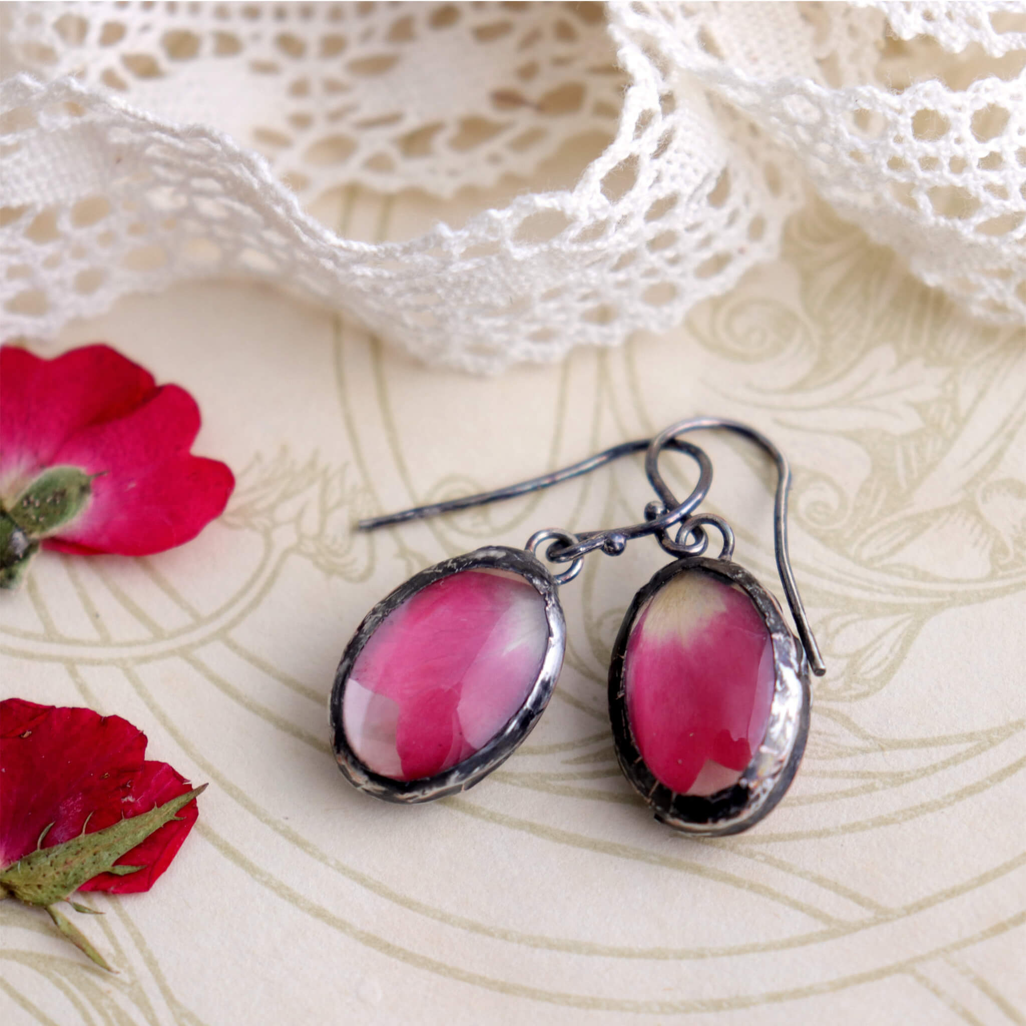 Rose petal earrings lying on an old book