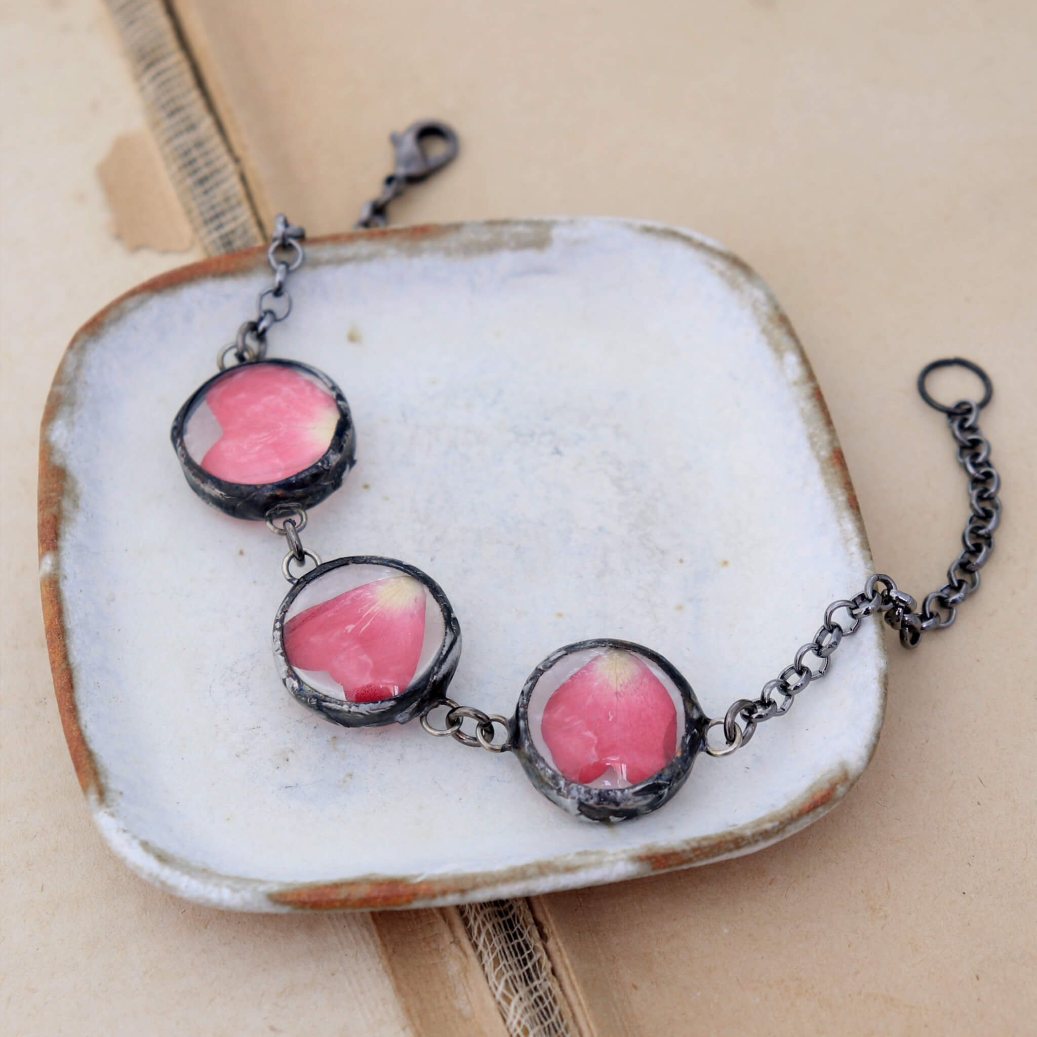 Pressed rose petal bracelet lying on a white dish