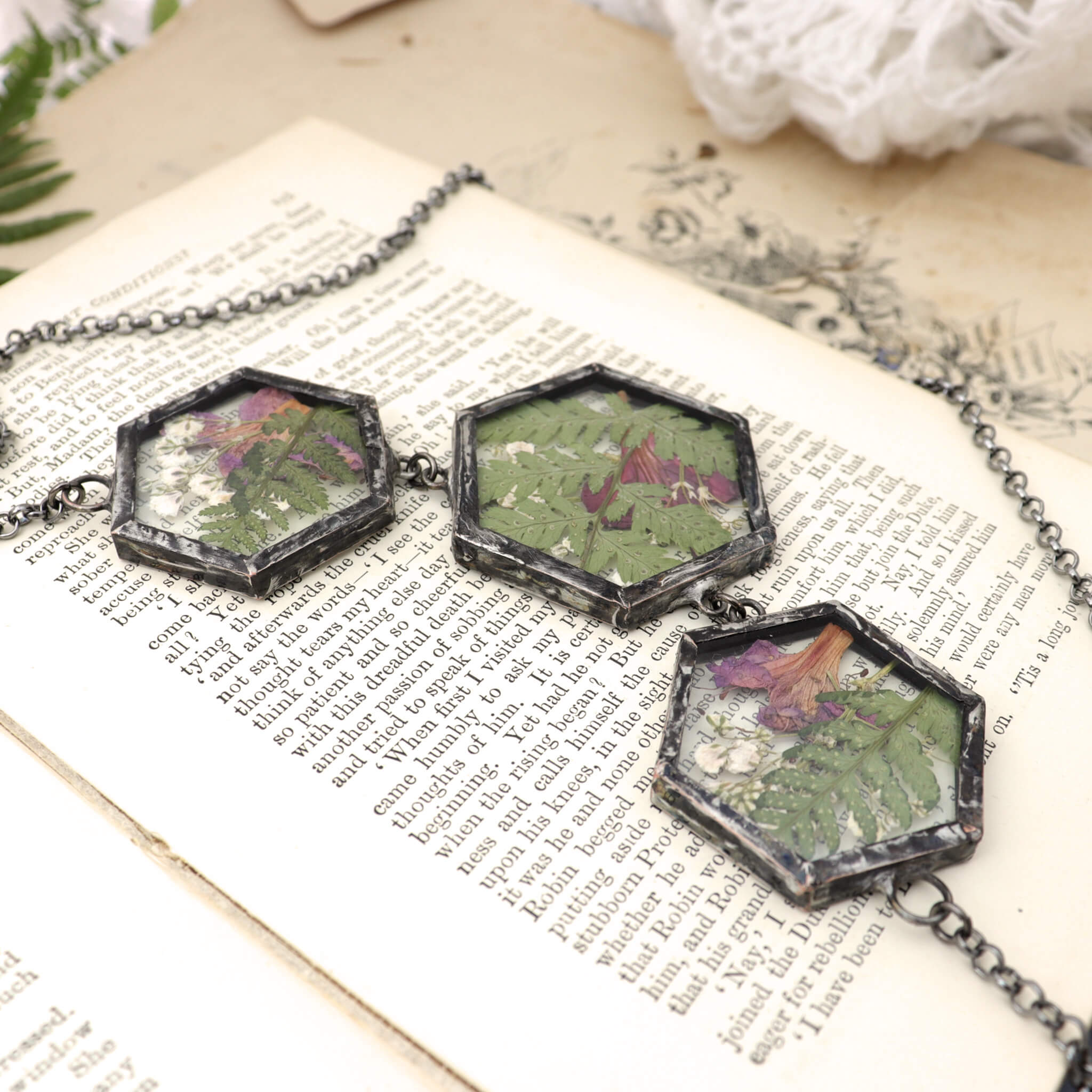 Three panels botanical statement necklace lying on an open book