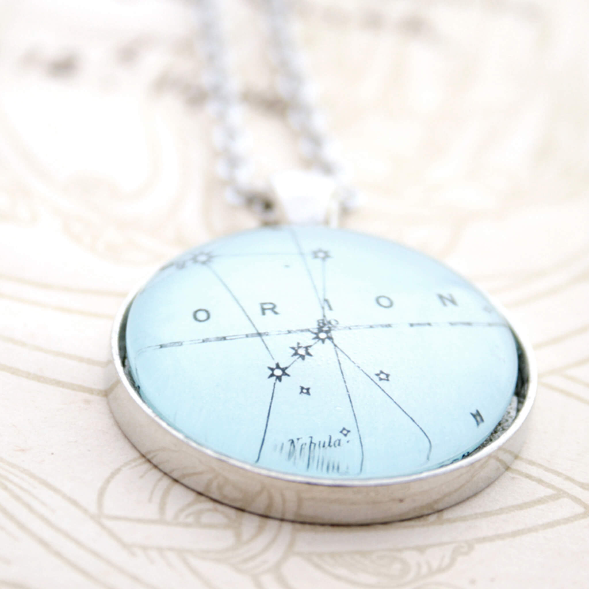 Silver tone pendant necklace featuring map of Orion constellation