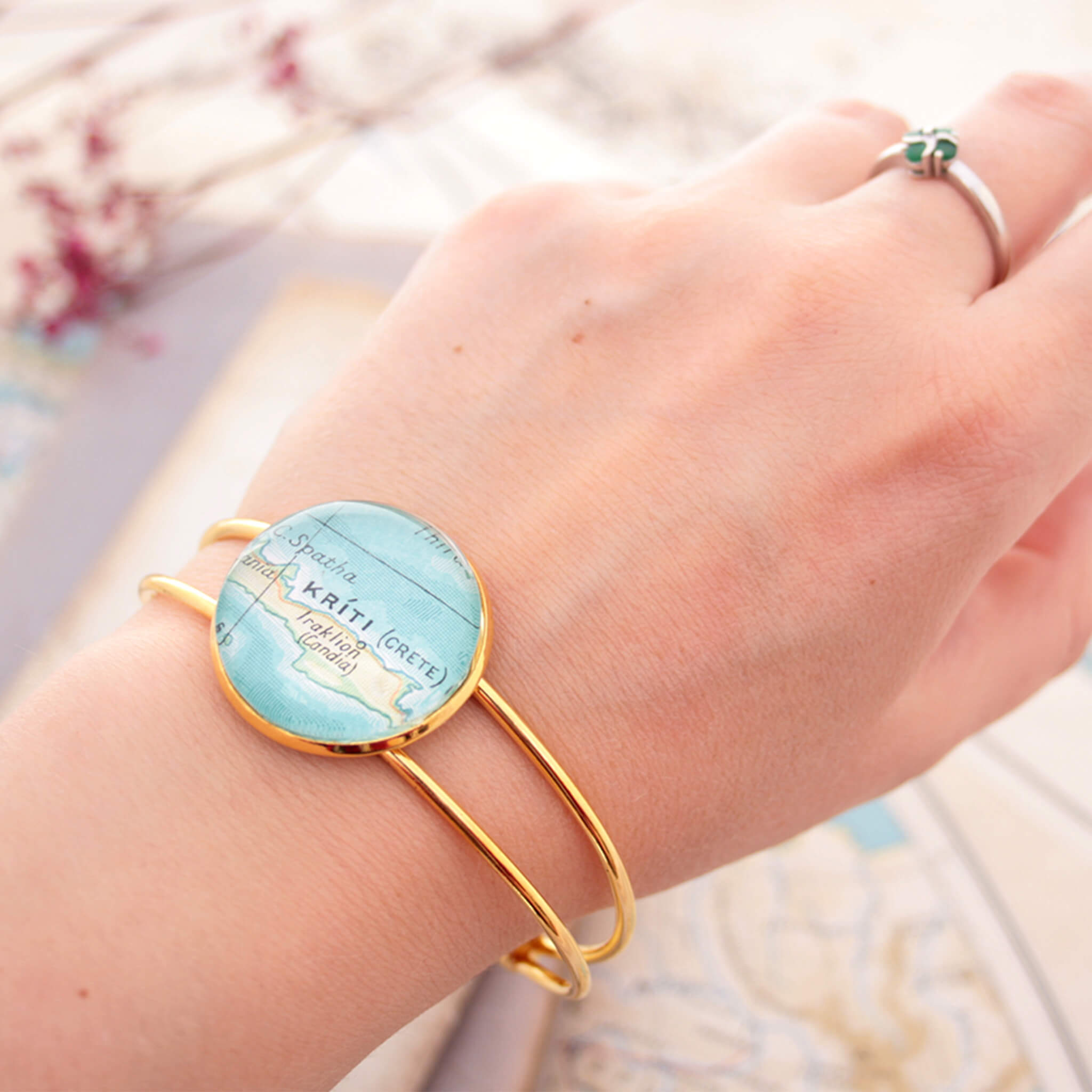 Gold bangle bracelet with geographical map of Kriti worn on hand