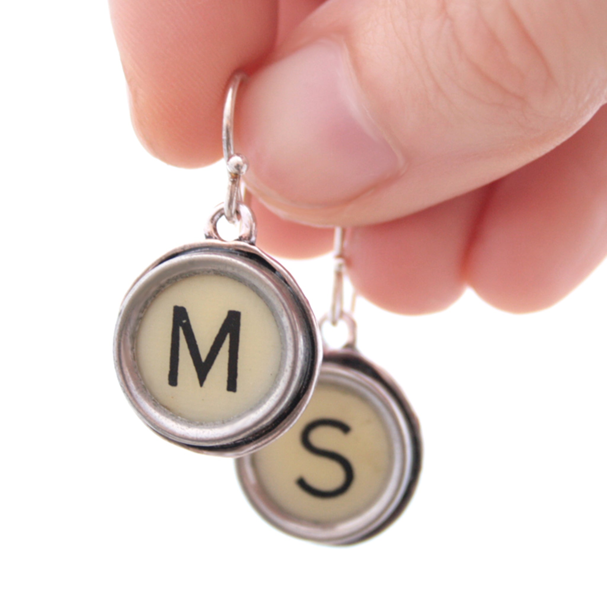 M and S Ivory Typewriter keys turned into initial earrings hold in hand