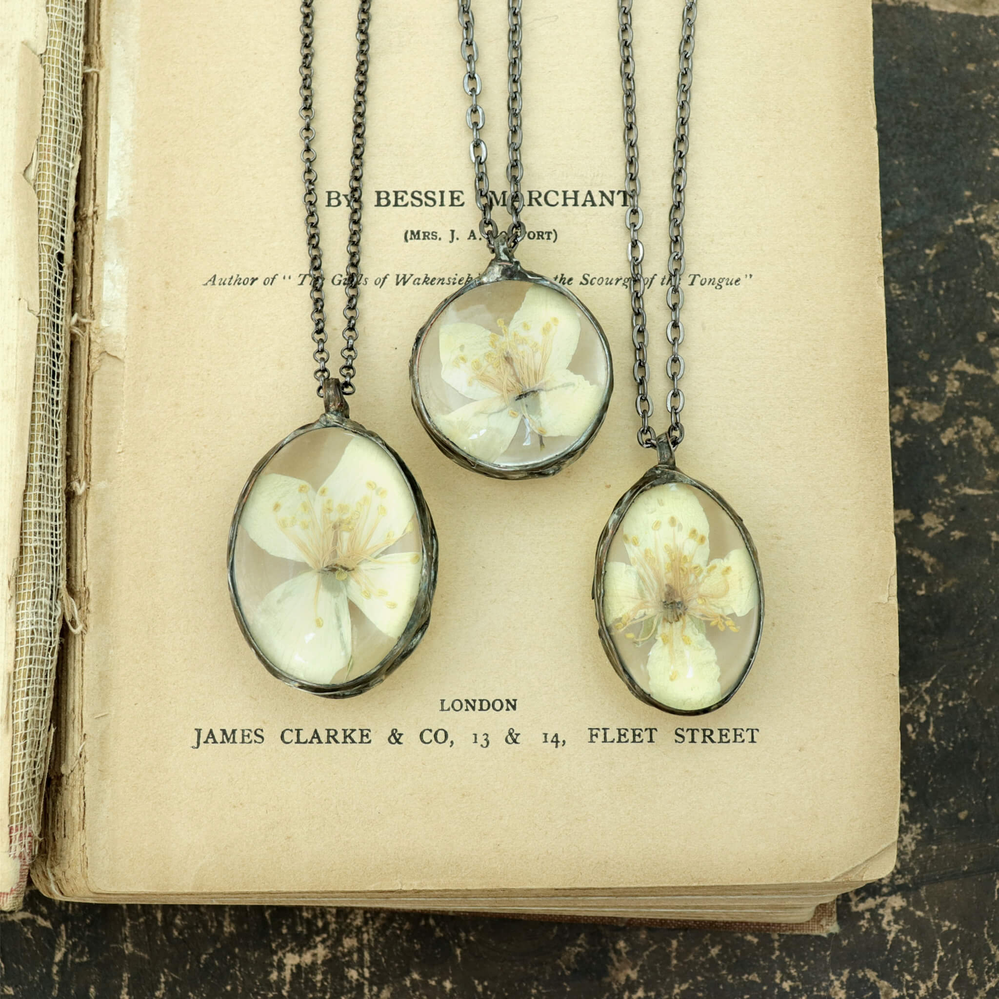 Three jasmine necklaces lying side by side on a vintage book