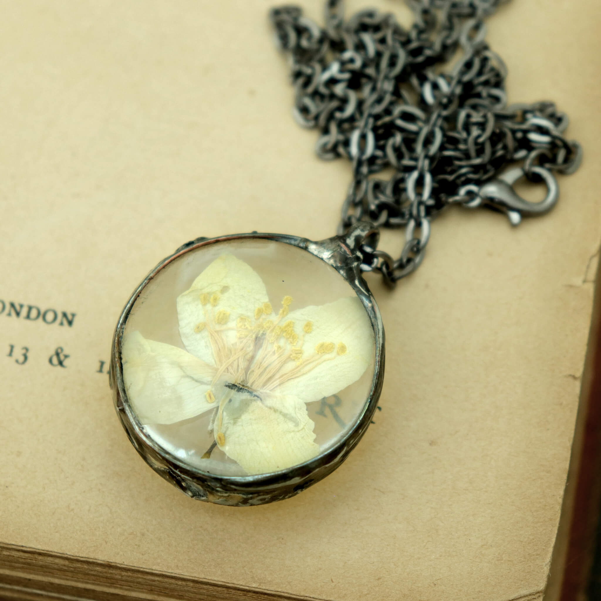 round jasmine necklace lying on a vintage book