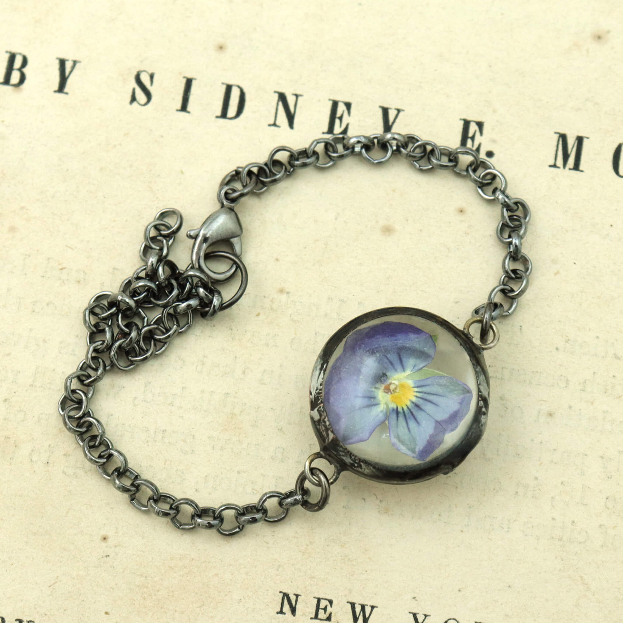 violet pansy bracelet lying on a vintage book