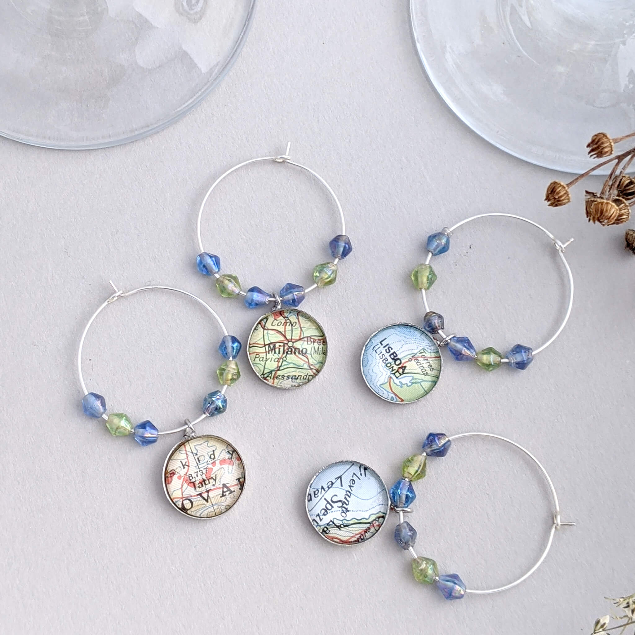 wine glass charms in green and blue tone personalised with map locations