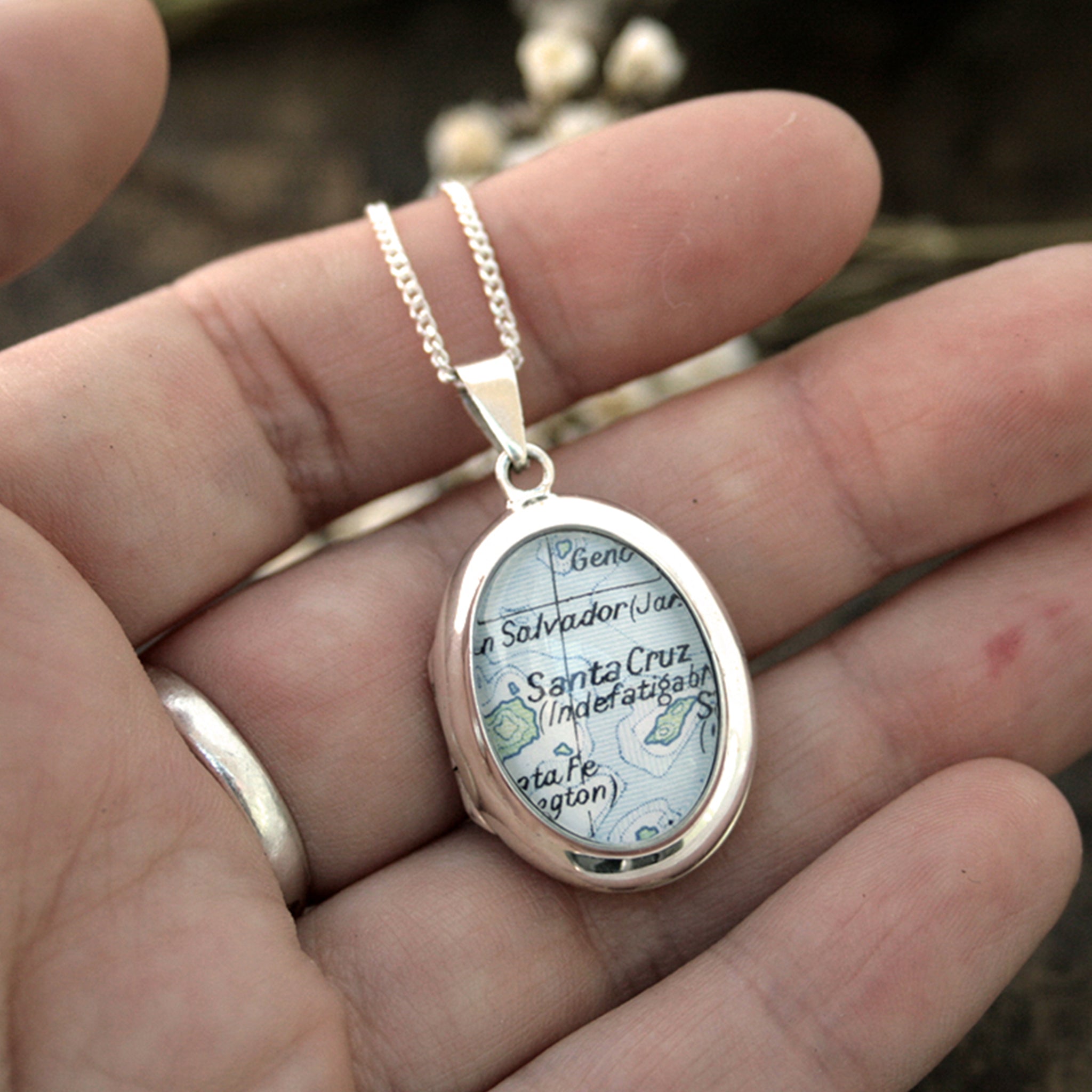 Hold in hand sterling silver locket necklace featuring map of Santa Cruz