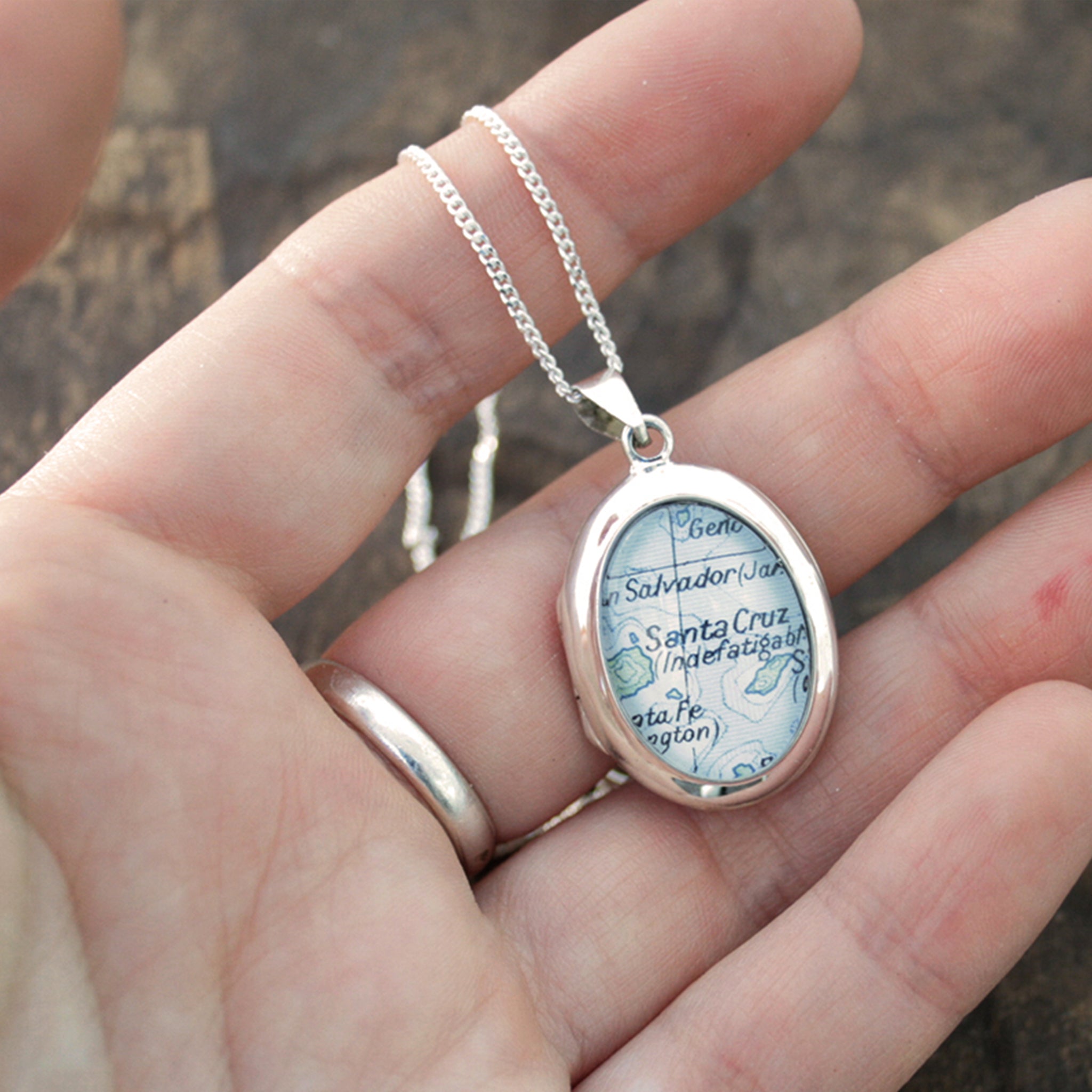 Hold in hand sterling silver locket necklace featuring map of Santa Cruz