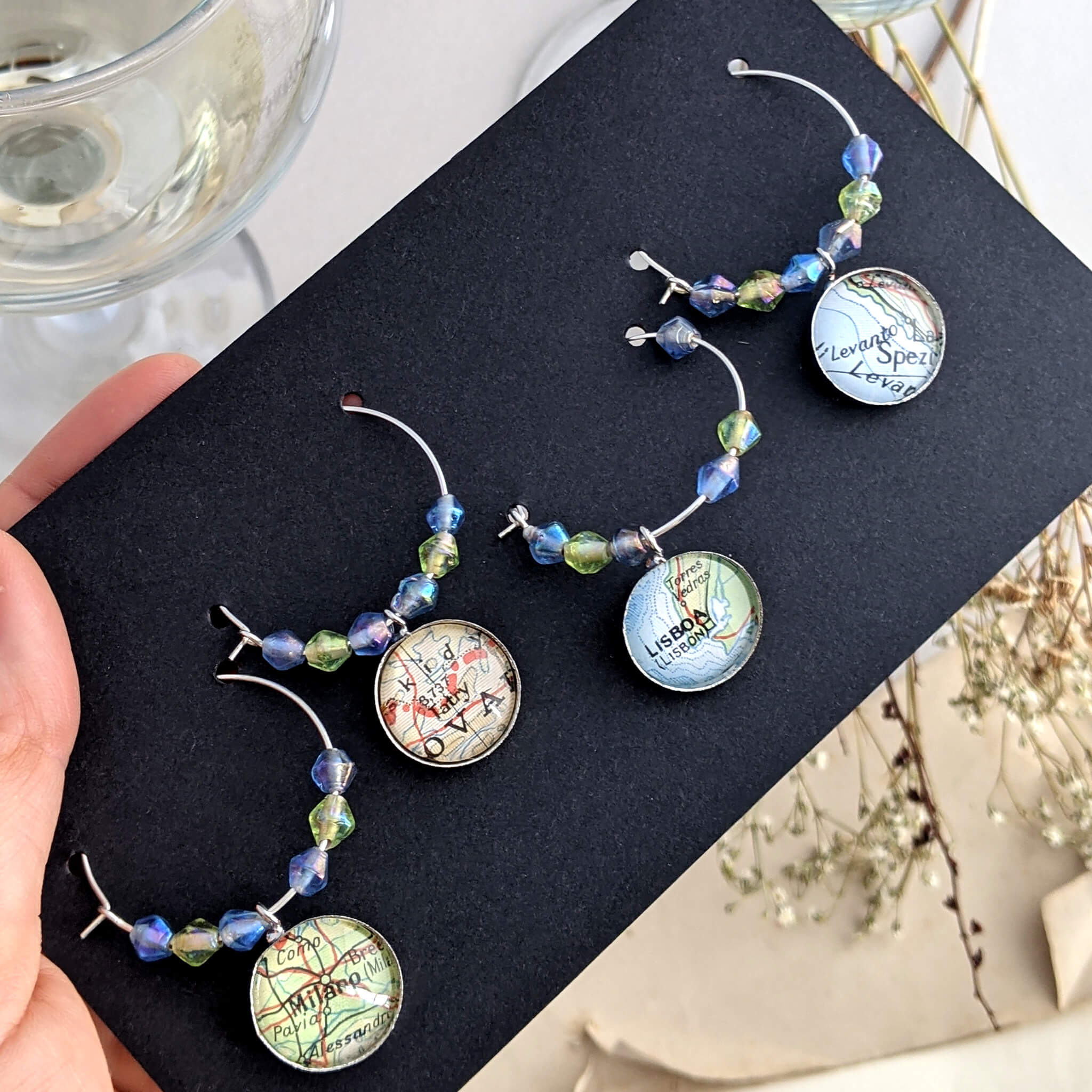 set of 4 wine glass charms personalised with map locations on a black card