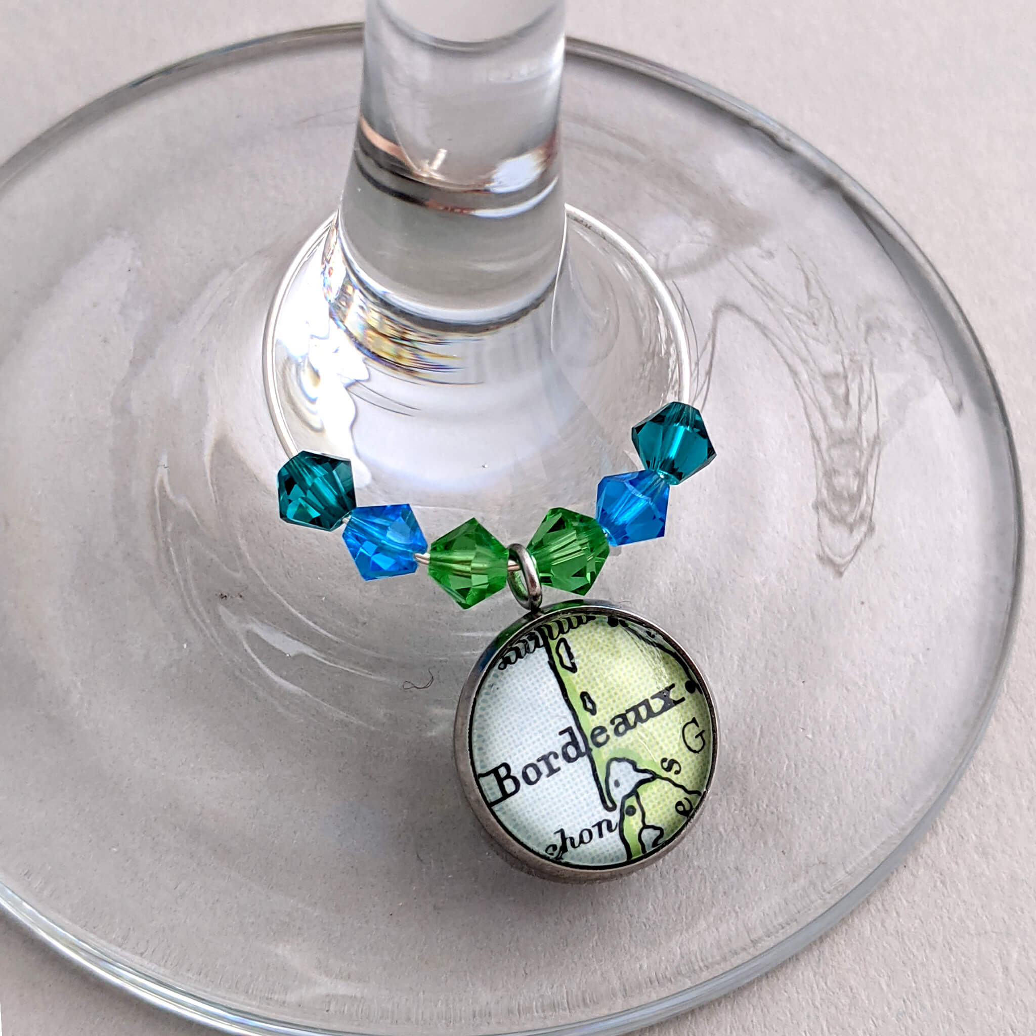 wine glass charm in green and blue tone personalised with map of Bordeaux