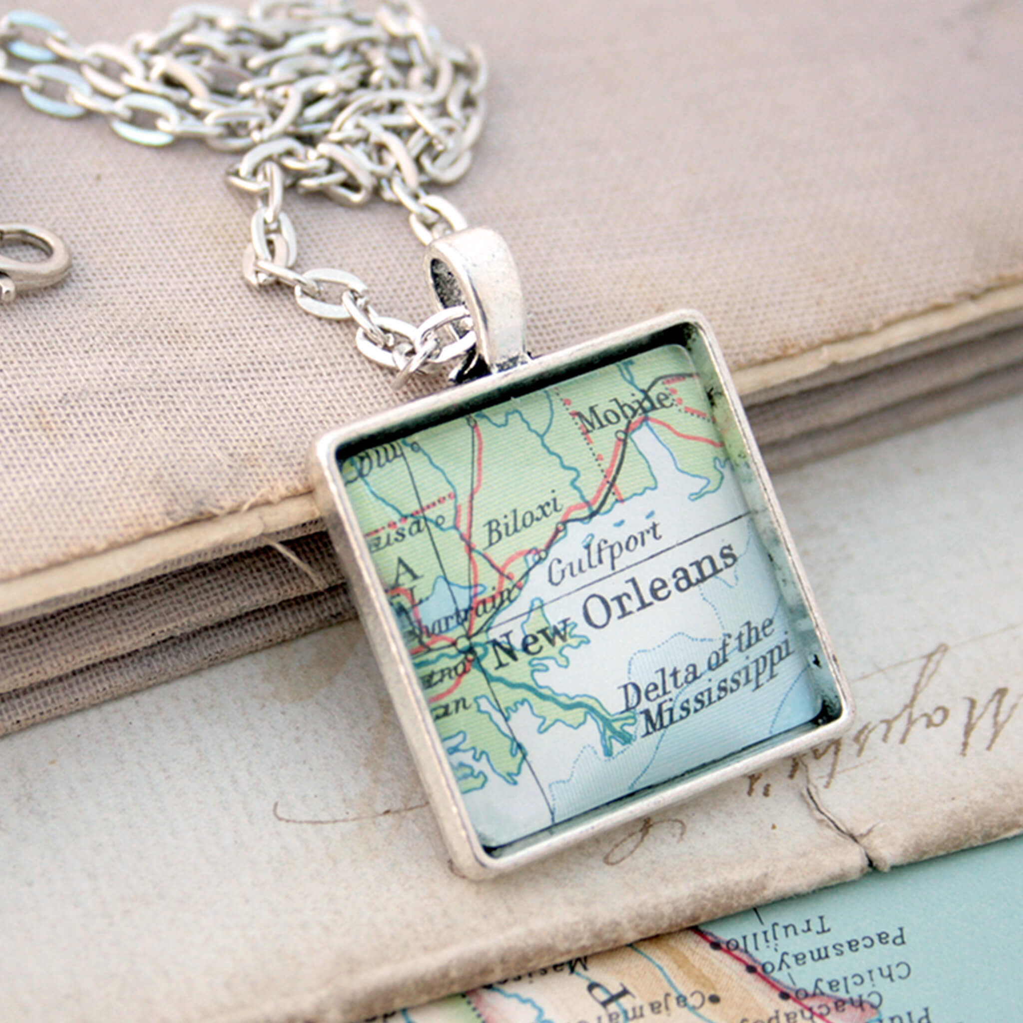 Silver coloured, square pendant necklace featuring map of New Orleans