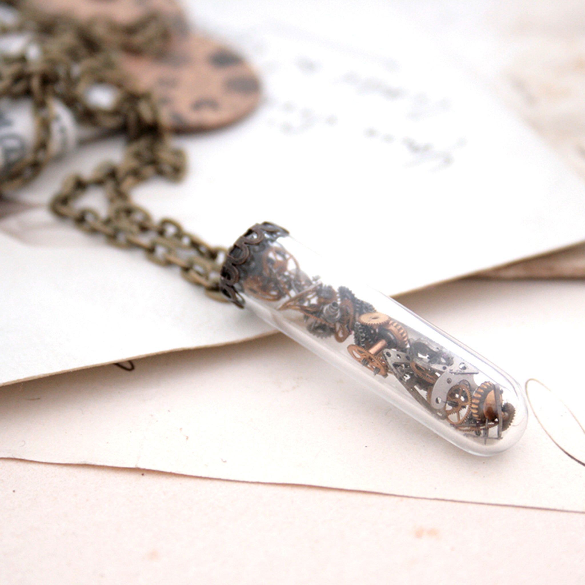 steampunk terrarium pendant necklace made of glass in vial shape filled with watch parts