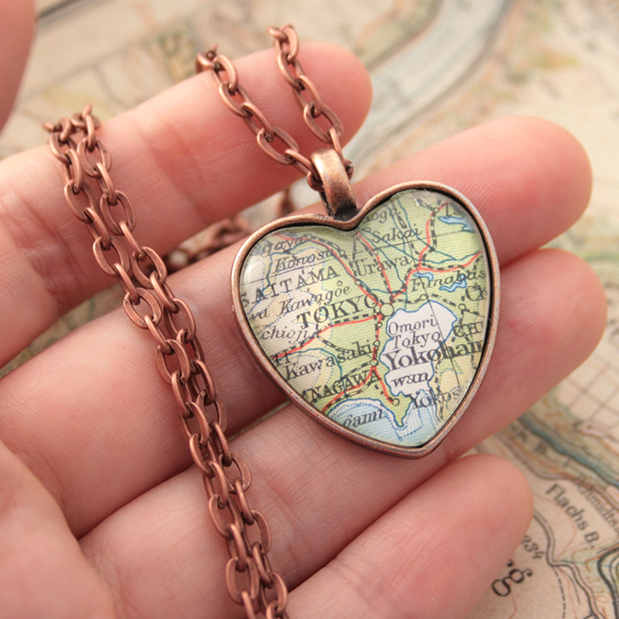 Hold in hand heart shaped pendant necklace in copper tone featuring map of Tokyo