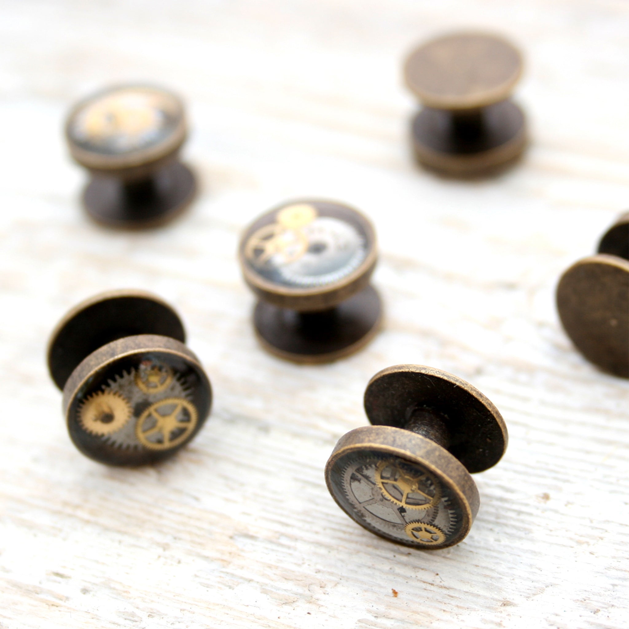 Antique bronze tone tuxedo studs featuring vintage watch parts filled with resin