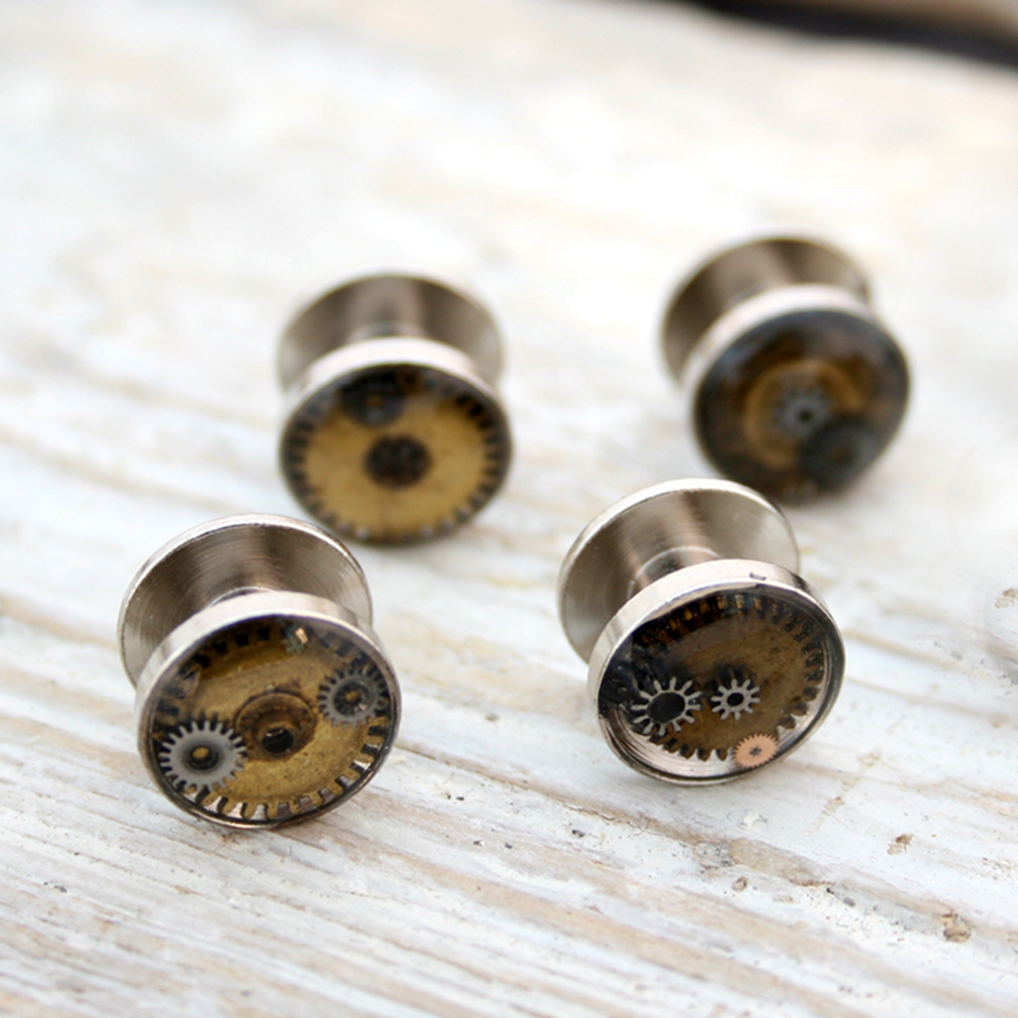 Silver tone tuxedo studs featuring vintage watch parts filled with resin