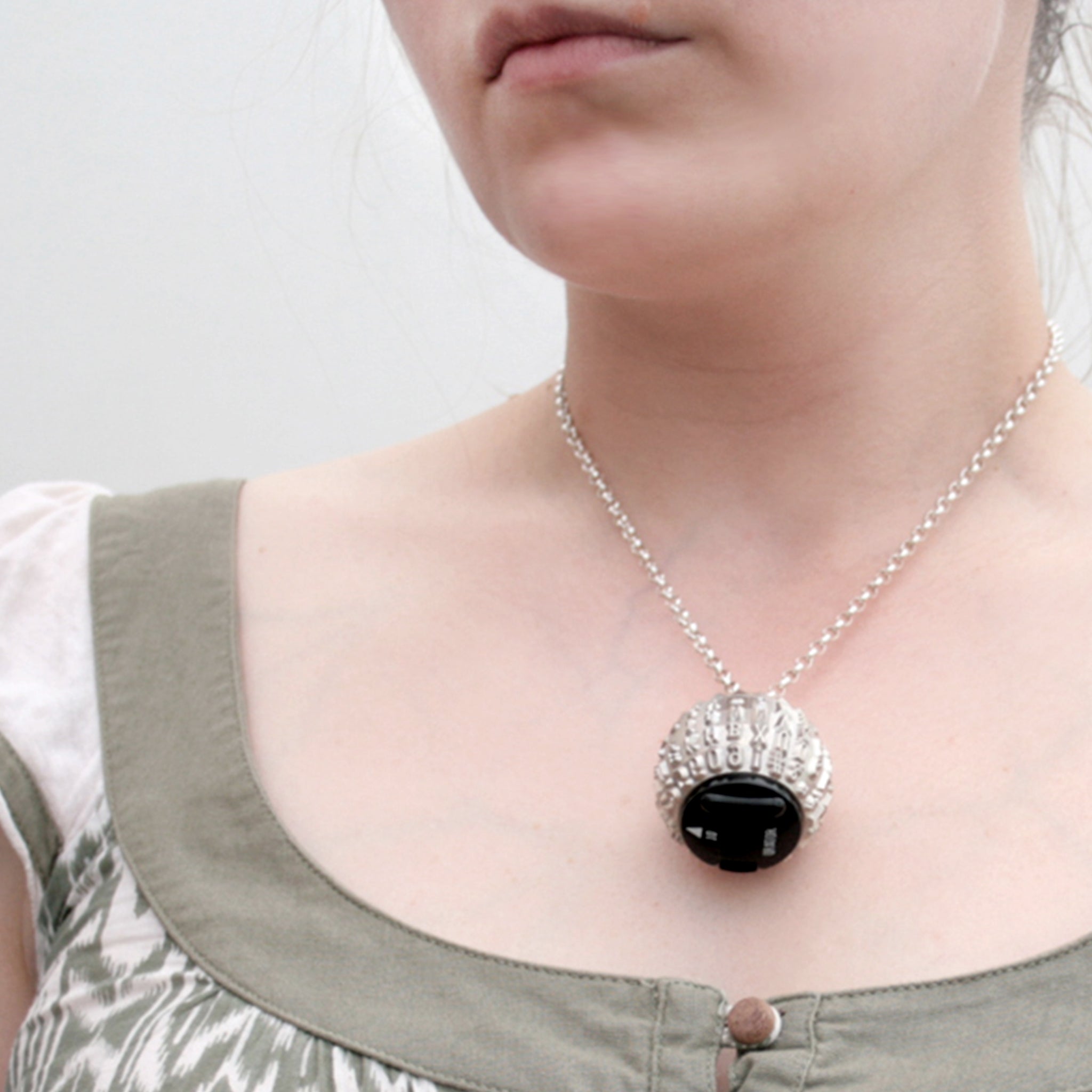 IBM Selectric typeball with sterling silver bead turned into quirky necklace worn by a model
