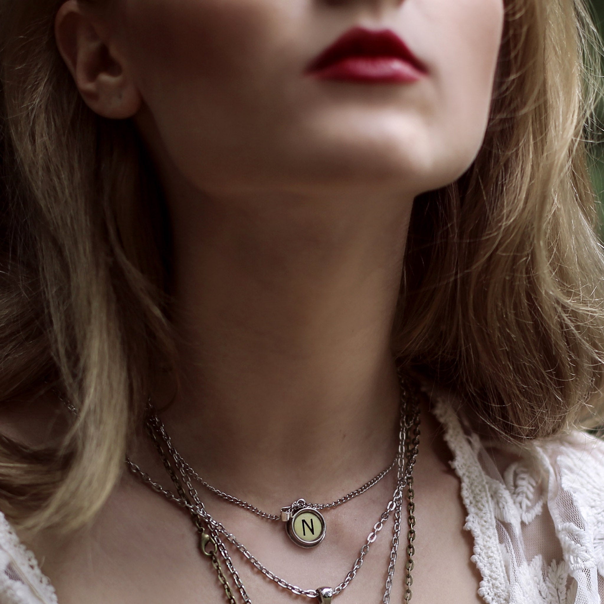 Model wearing initial necklace made of authentic vintage ivory typewriter key