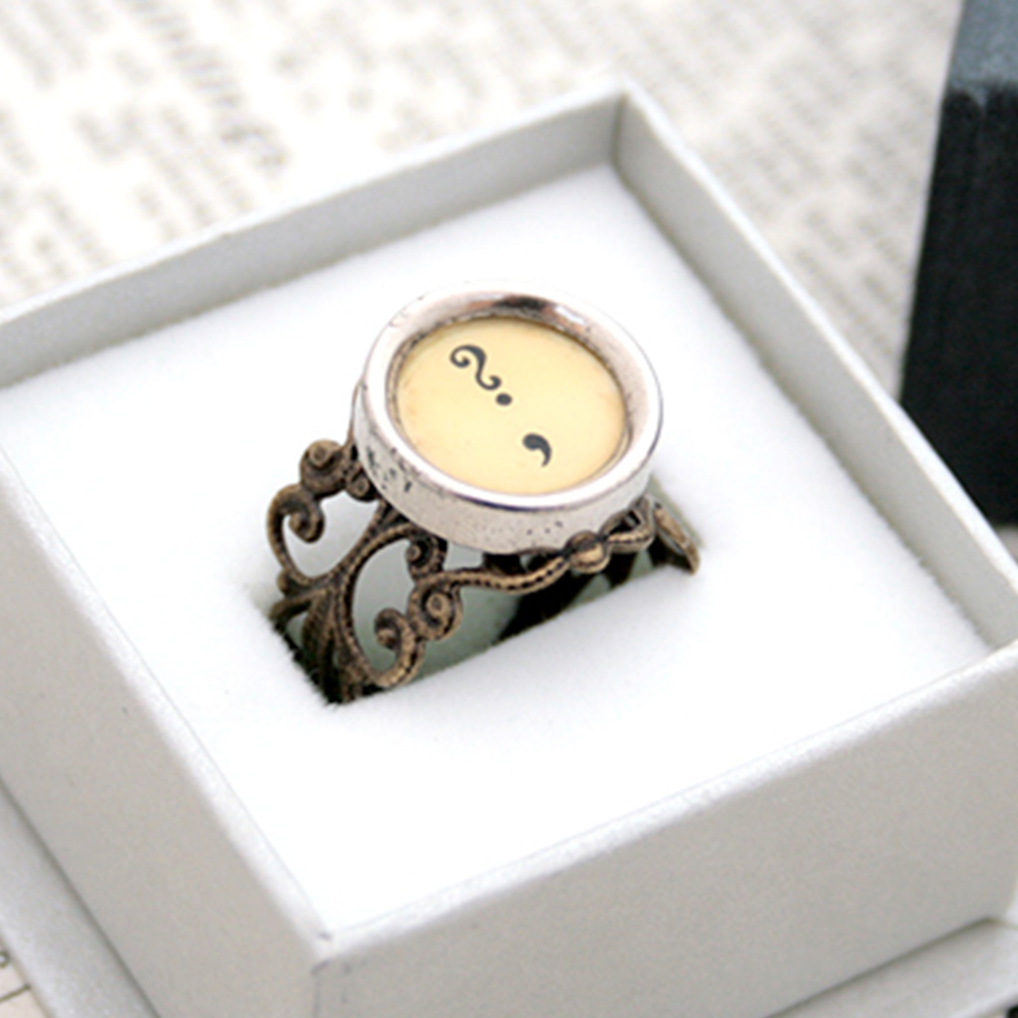 Ring with question mark and comma made of  typewriter key in ivory color in a box