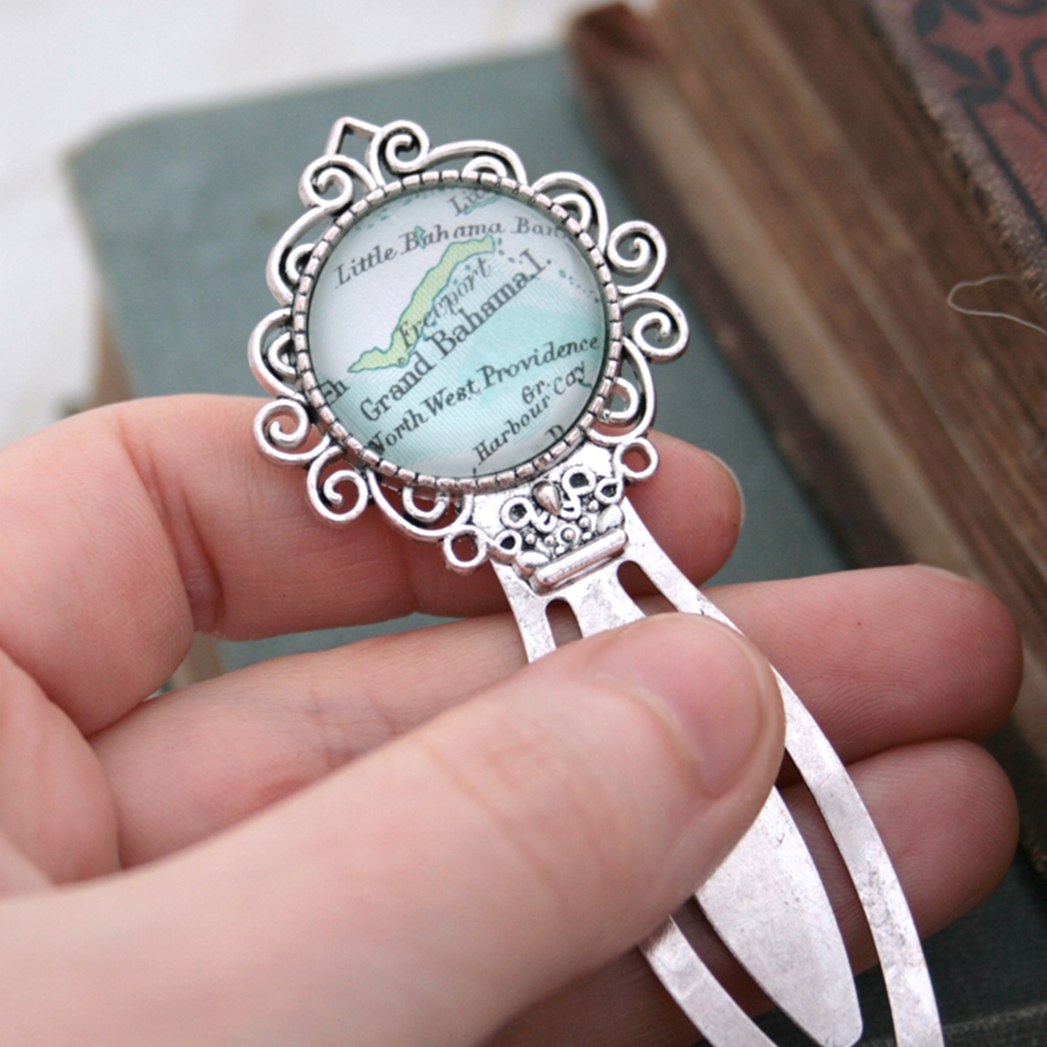 Hand holding personalised bookmark featuring Grand Bahama map in silver color