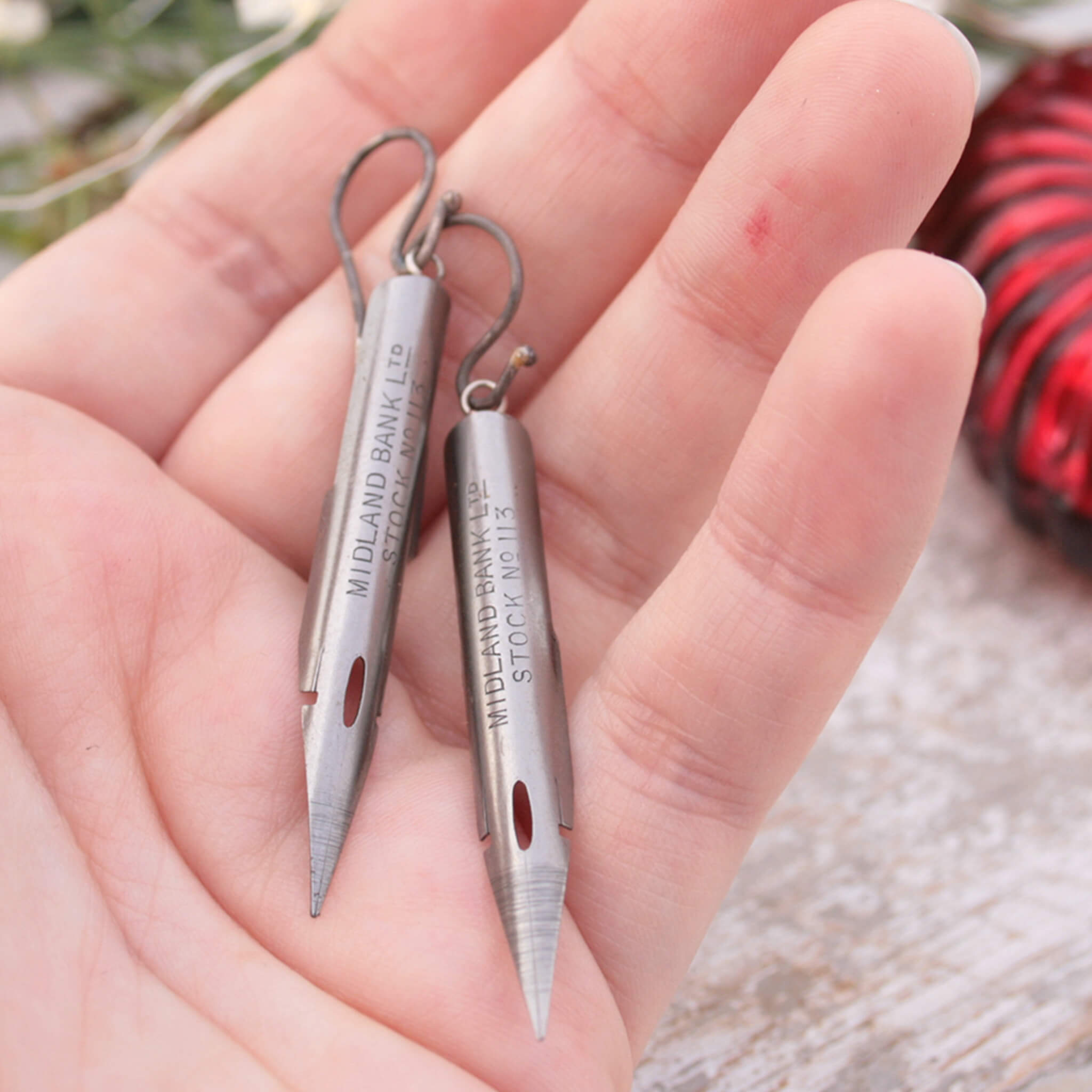 quirky earrings made of antique pen nibs hold in hand