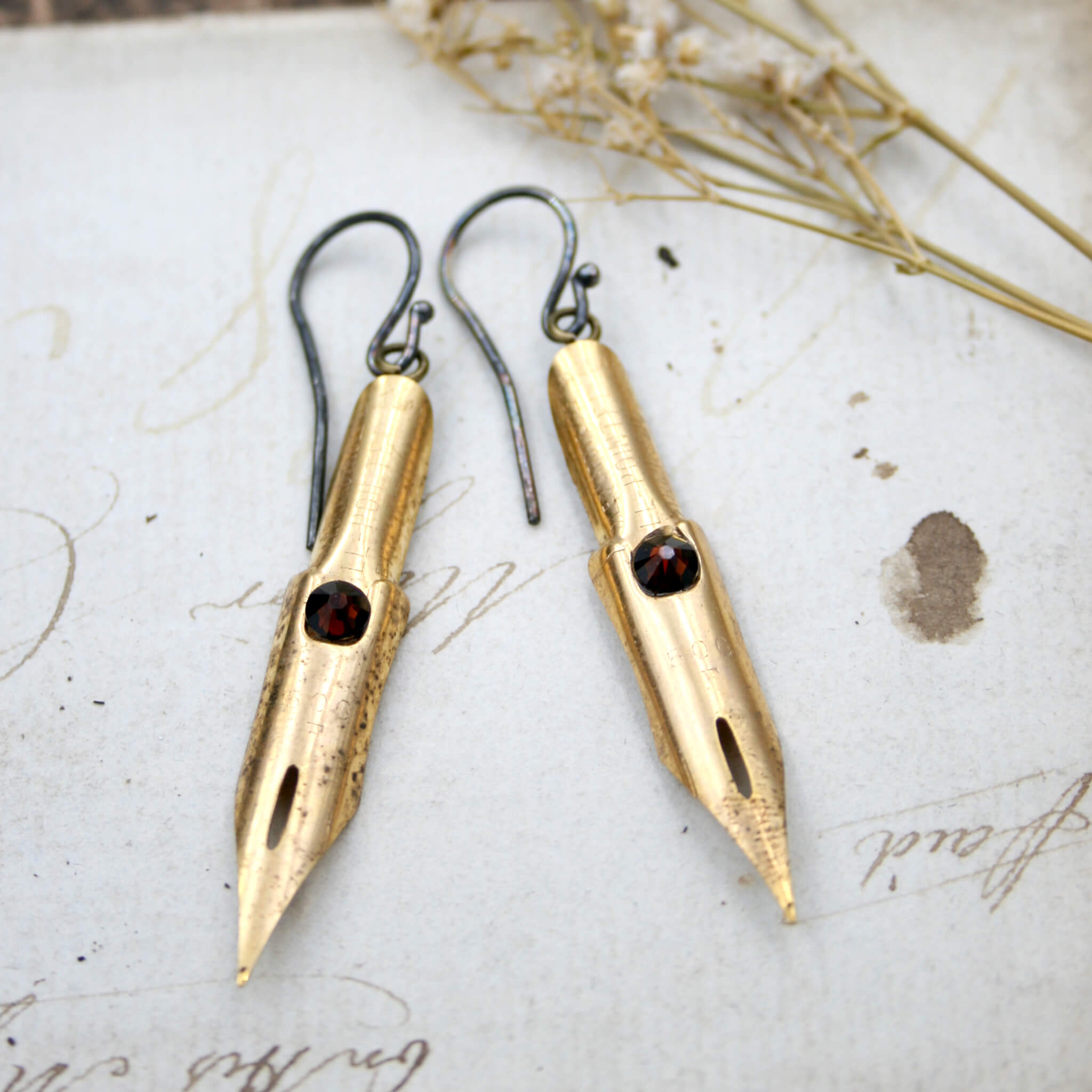 dark academia earrings made of gold coated pen nibs with smoked topaz swarovski crystals
