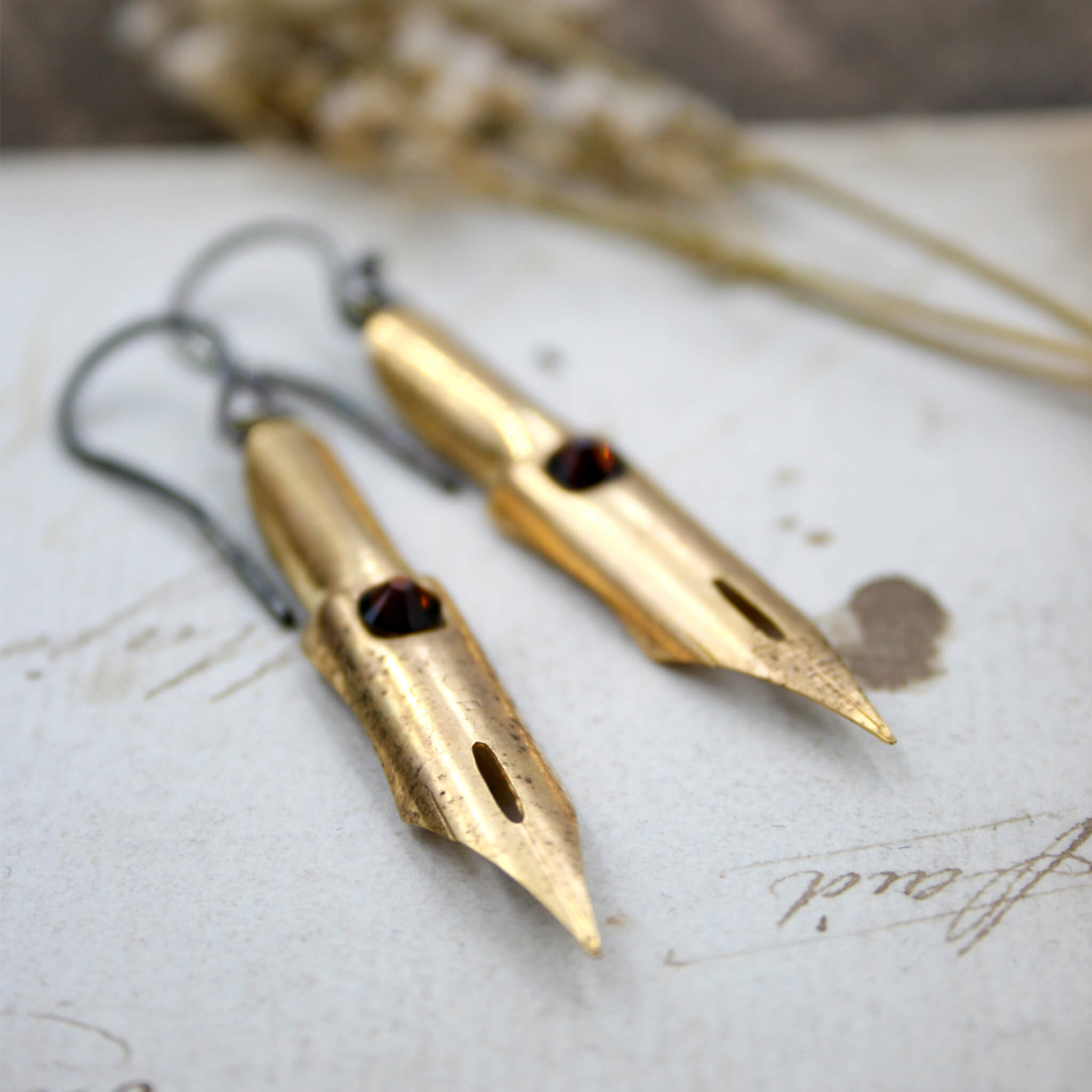 dark academia earrings made of gold coated pen nibs with smoked topaz swarovski crystals