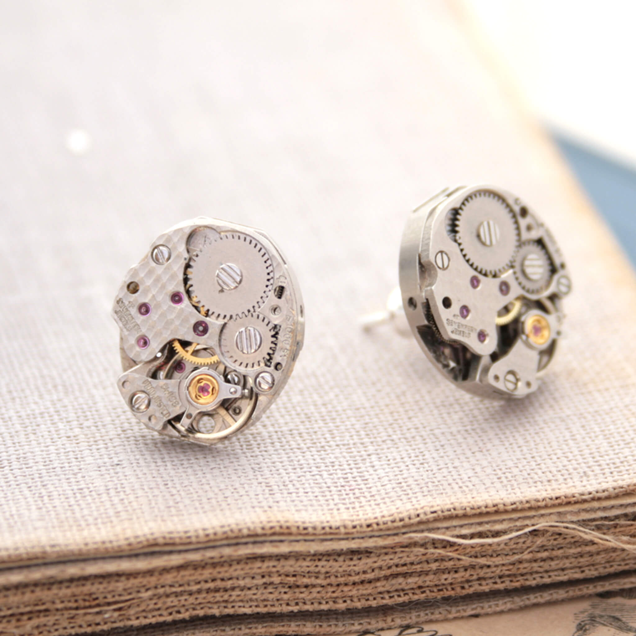 Watch movements turned into stud earrings lying on a vintage book