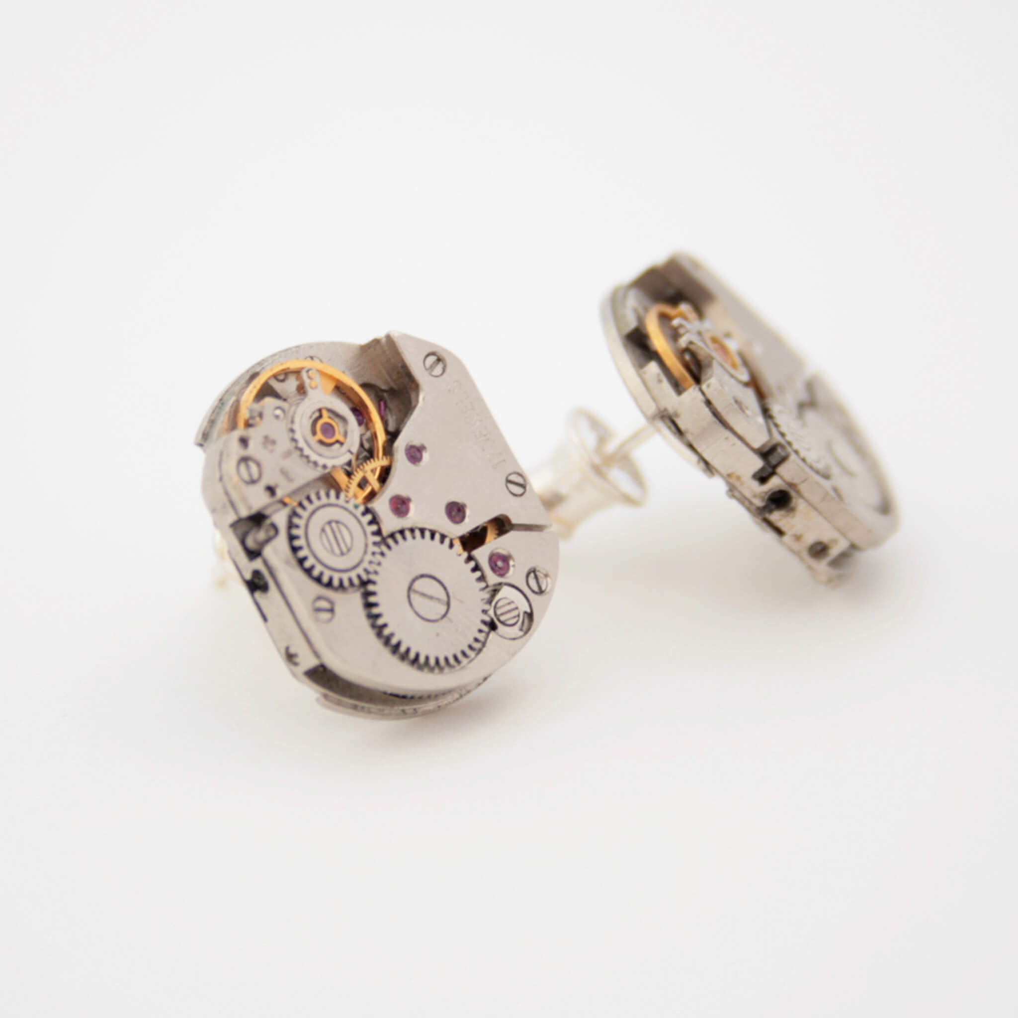 Rectangle Watch movements turned into stud earrings lying on a grey paper