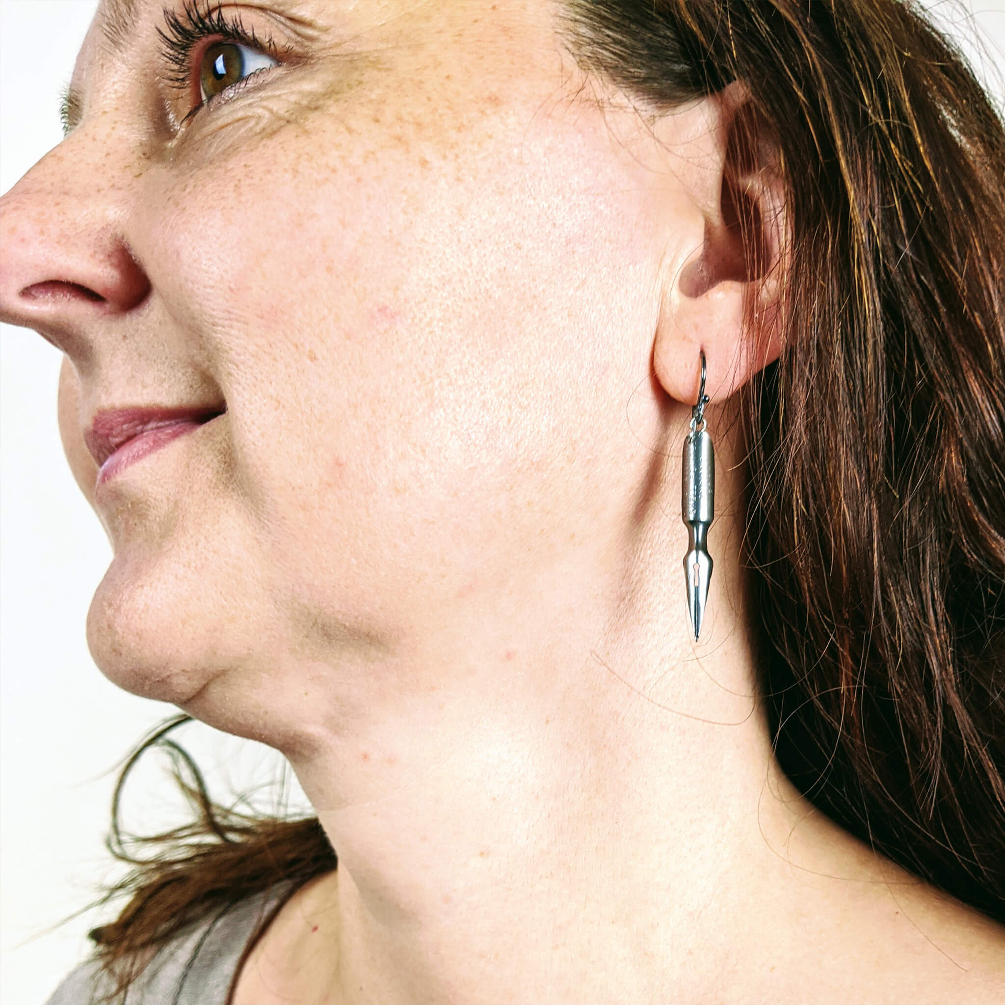 woman wearing quirky earrings made of antique pen nibs