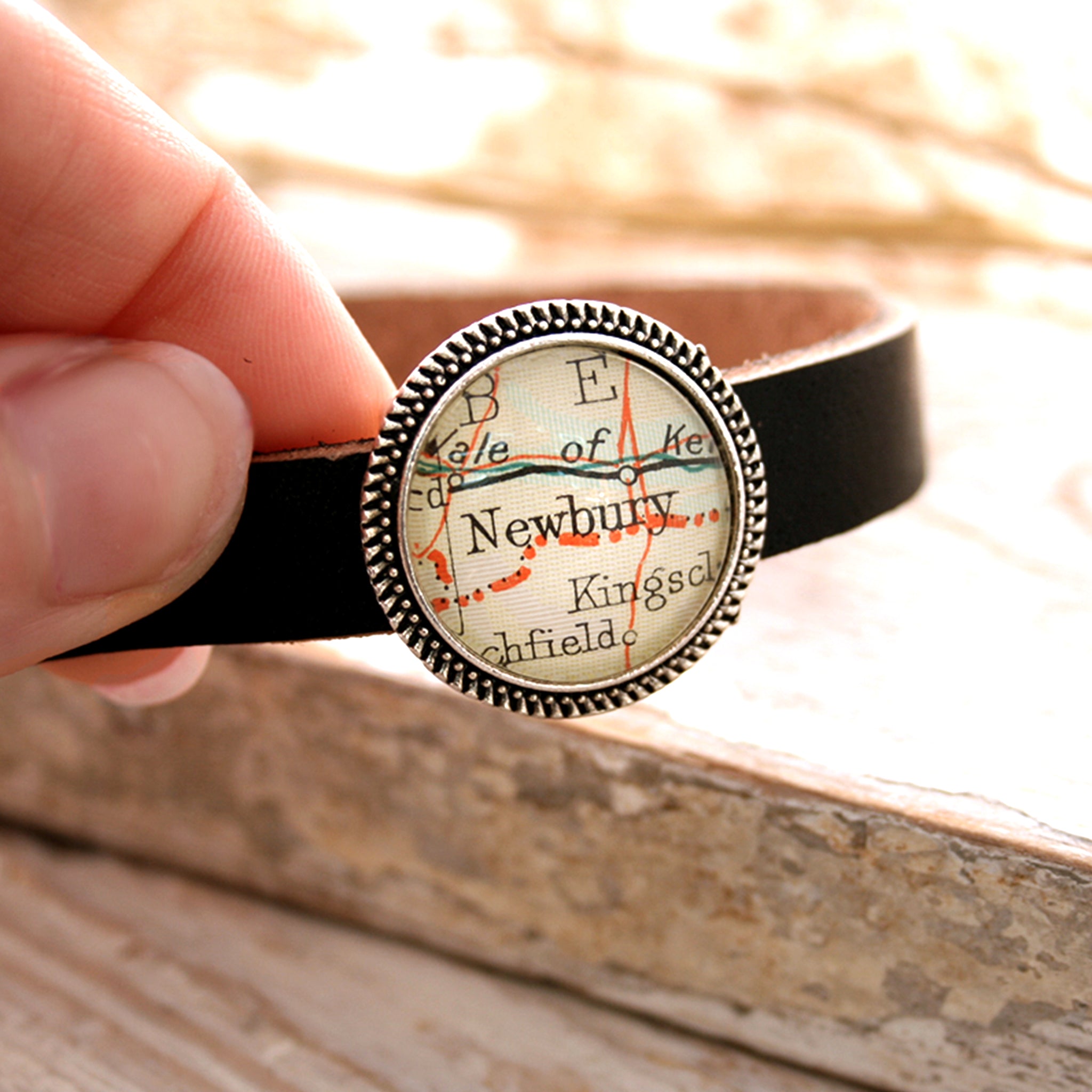 Personalised map bracelet featuring Newbury hold in hand