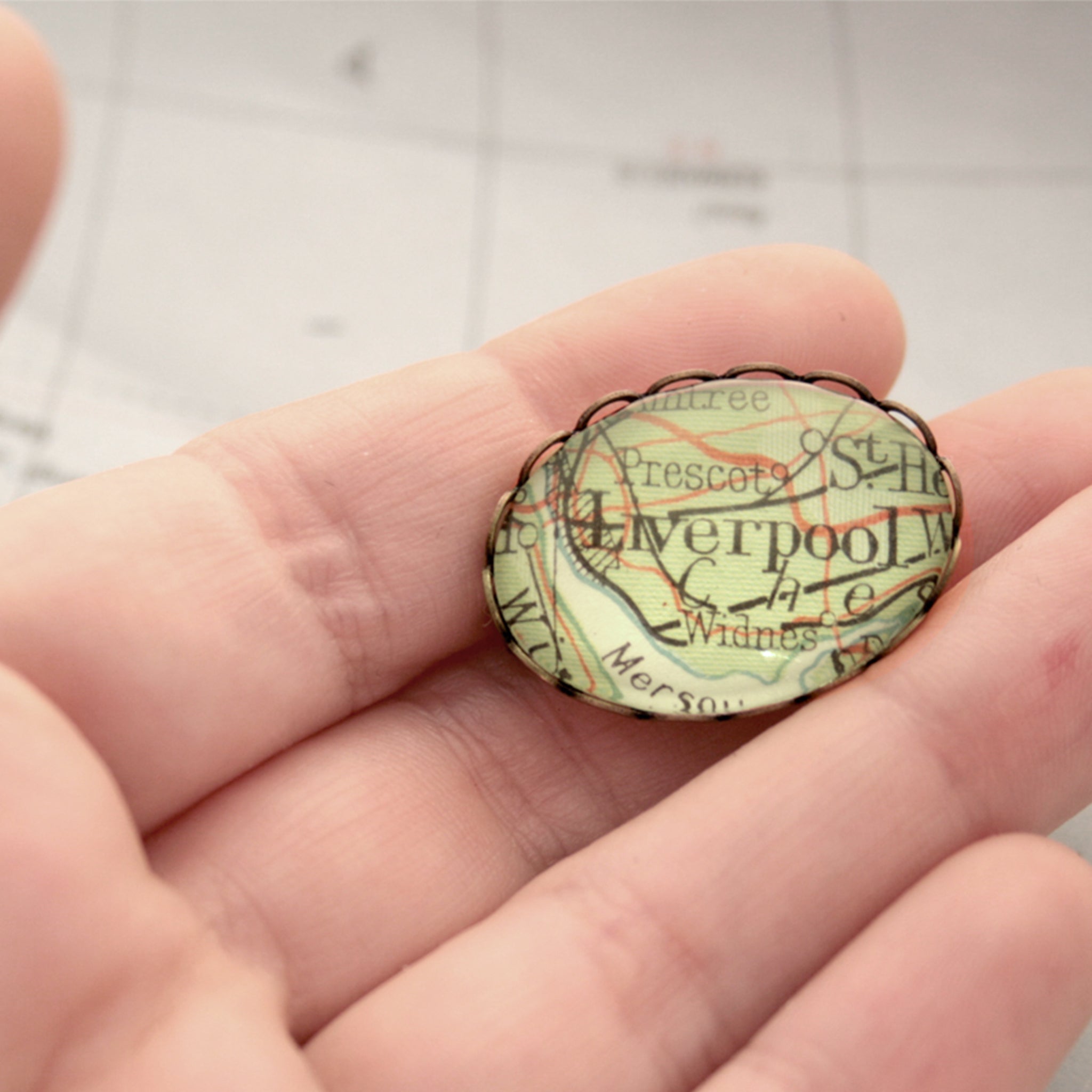 Antique Bronze brooch featuring map of Liverpool lying on hand