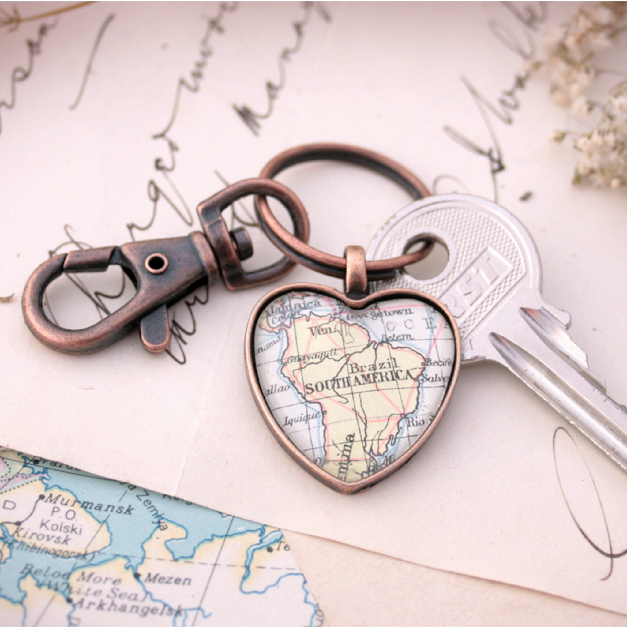 Heart shaped keychain in copper tone featuring map of South America