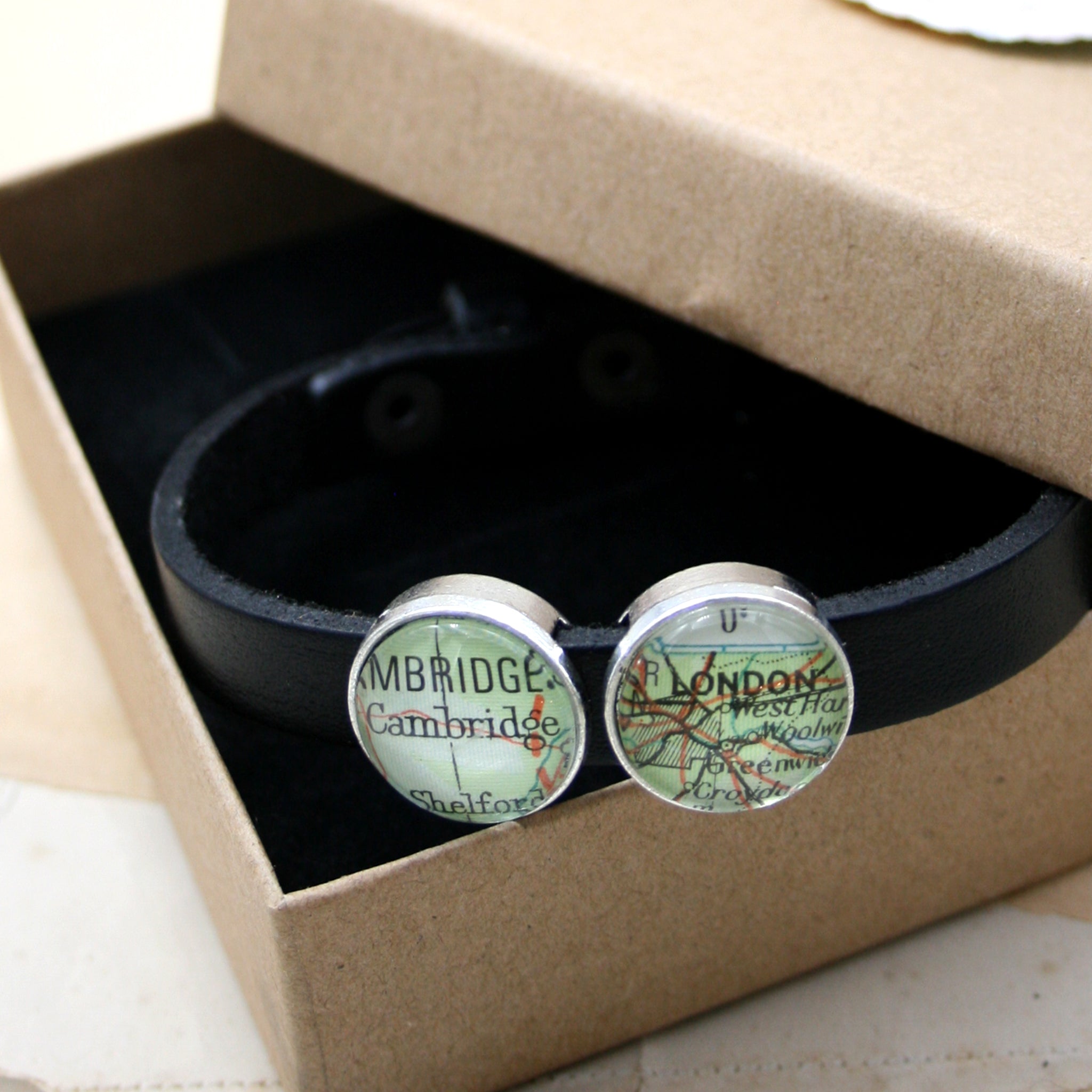Black leather bracelet featuring map locations in a box