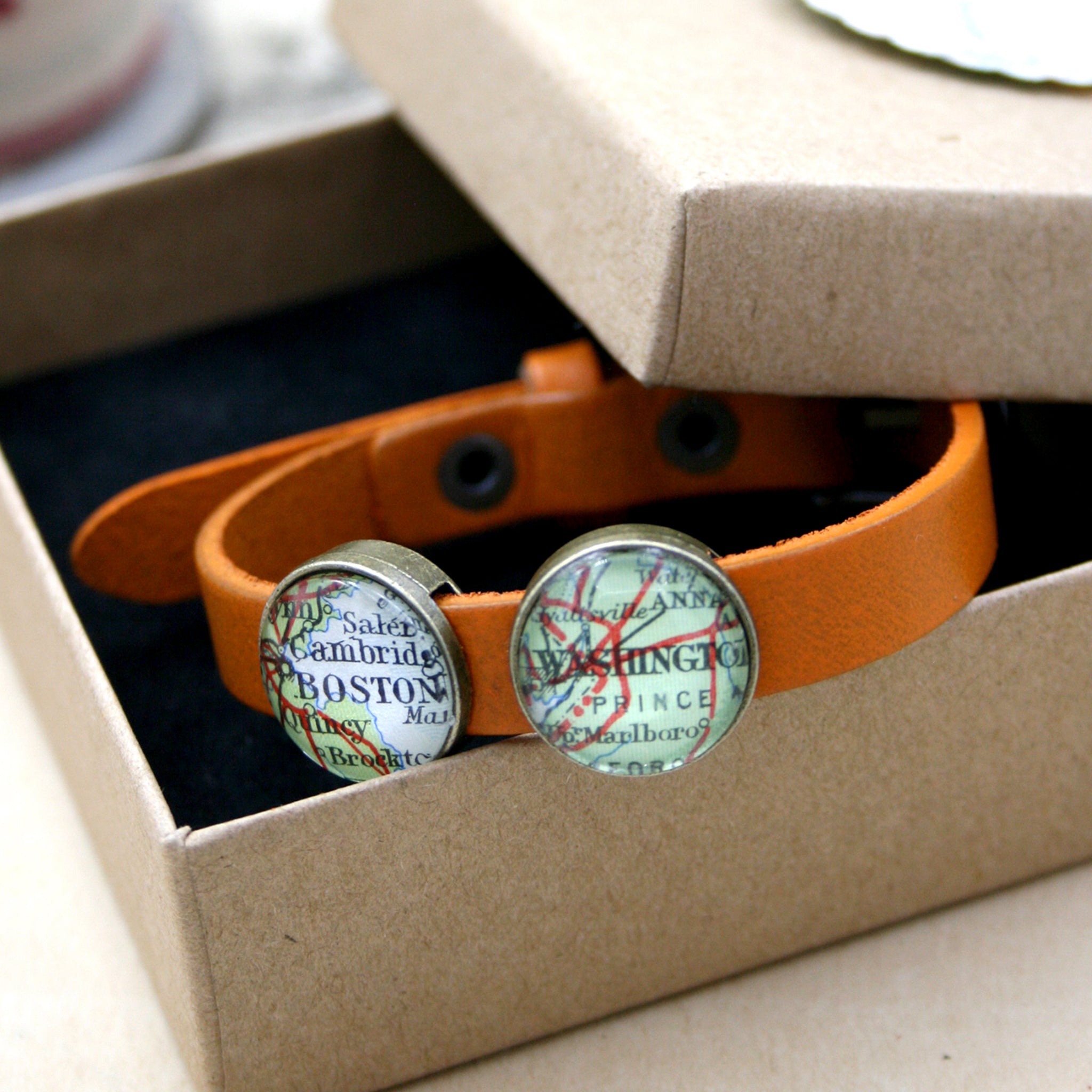 Orange leather bracelet featuring map locations in a box