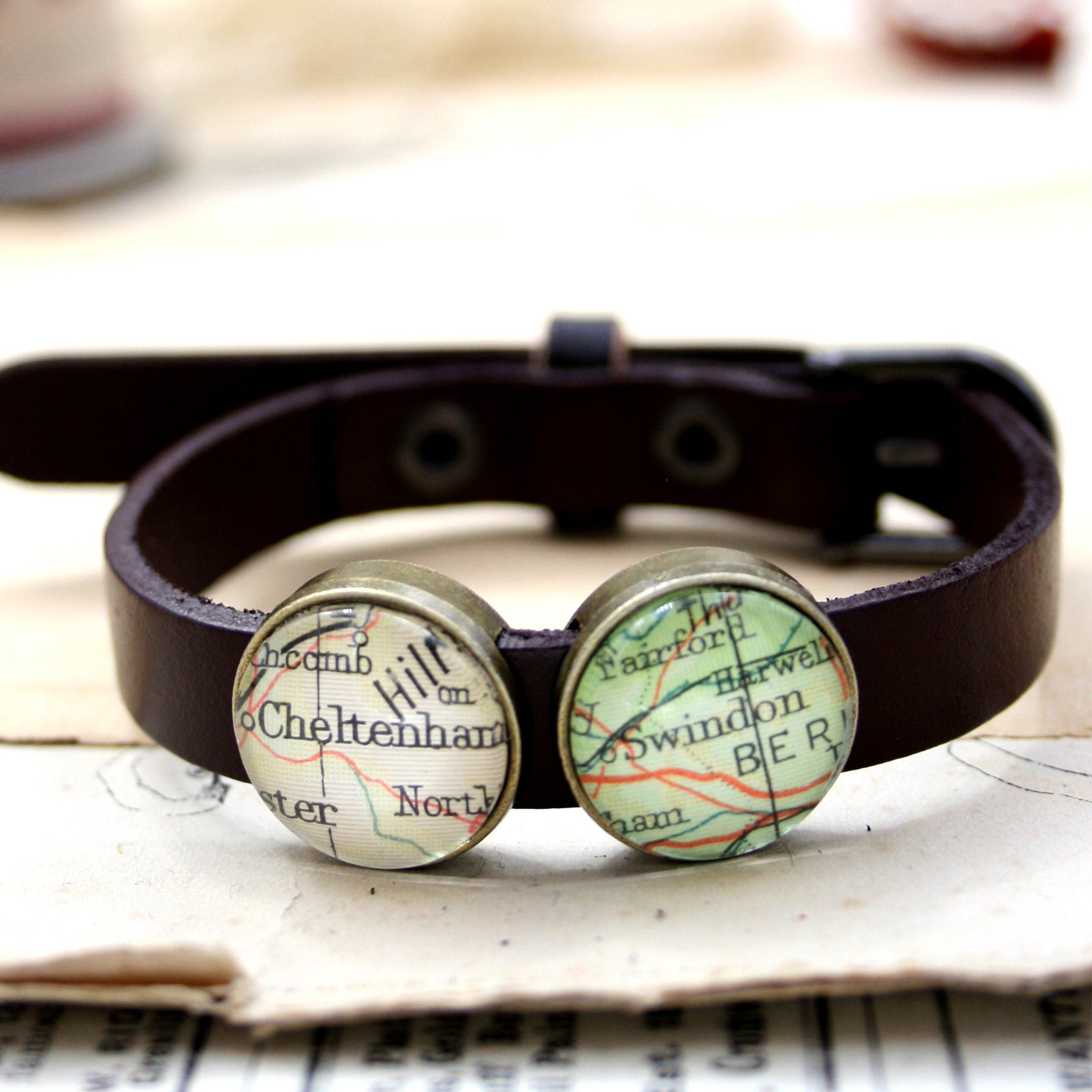 Brown leather bracelet featuring map locations