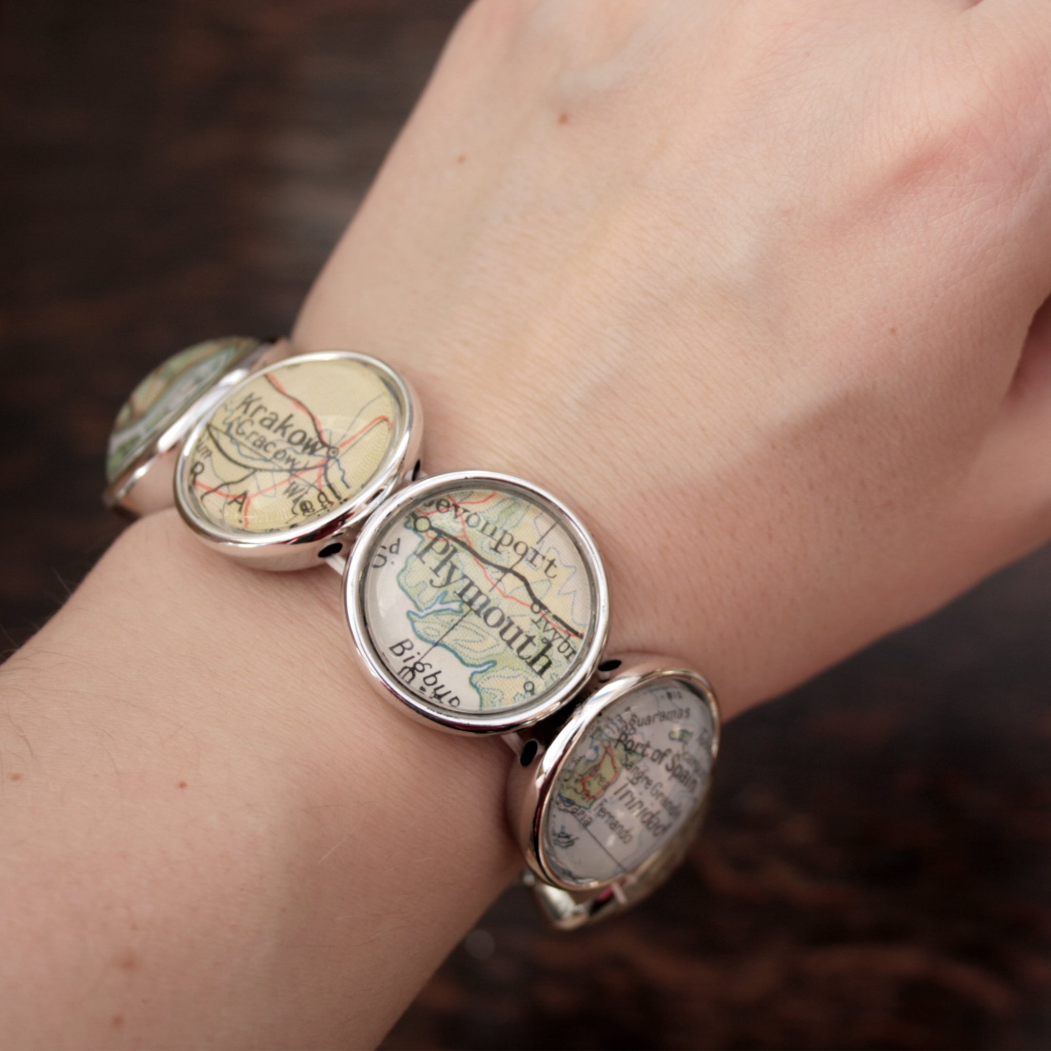 Worn on hand Stretchy bracelet in silver tone featuring custom map locations